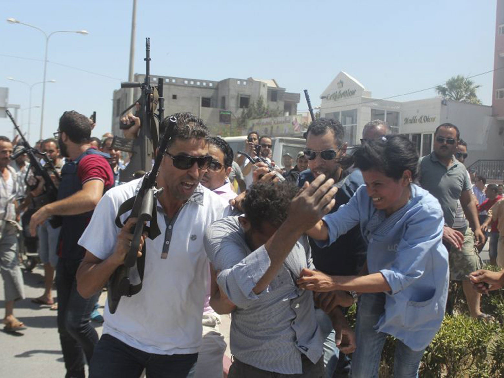 Police officers surround a man (C) suspected to be involved in an attack on a beachside hotel in Sousse, Tunisia June 26, 2015.