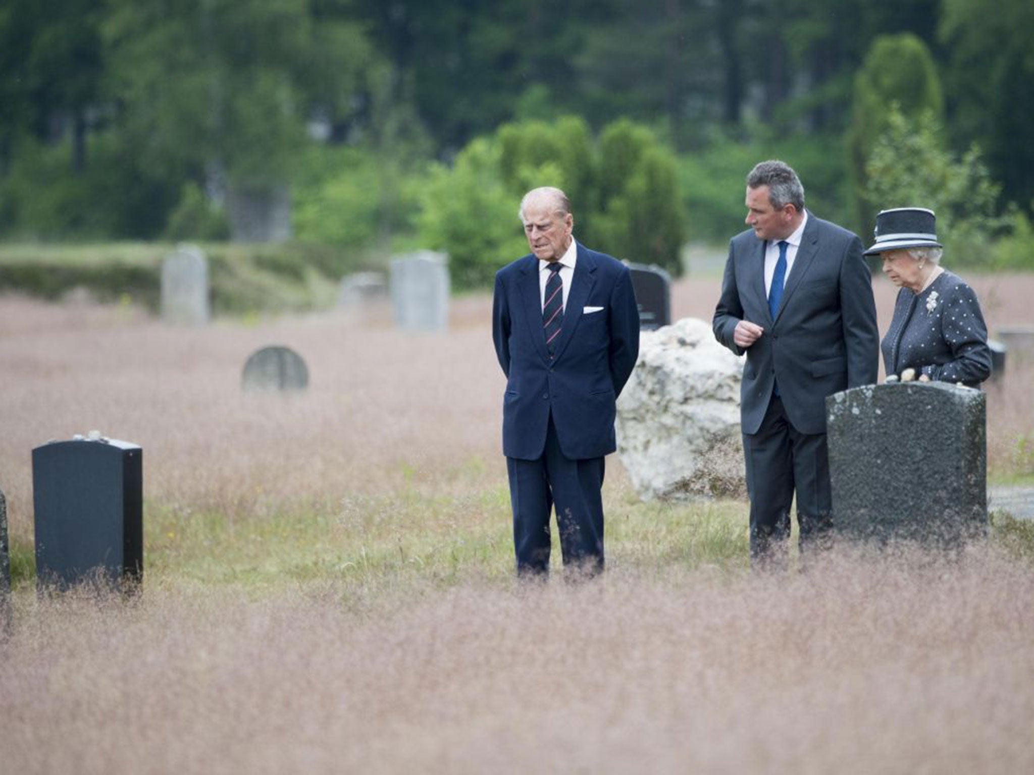 Queen Elizabeth II and Prince Philip, Duke of Edinburgh view the grave of Anne Frank during their visit of the concentration camp memorial at Bergen-Belsen on June 26