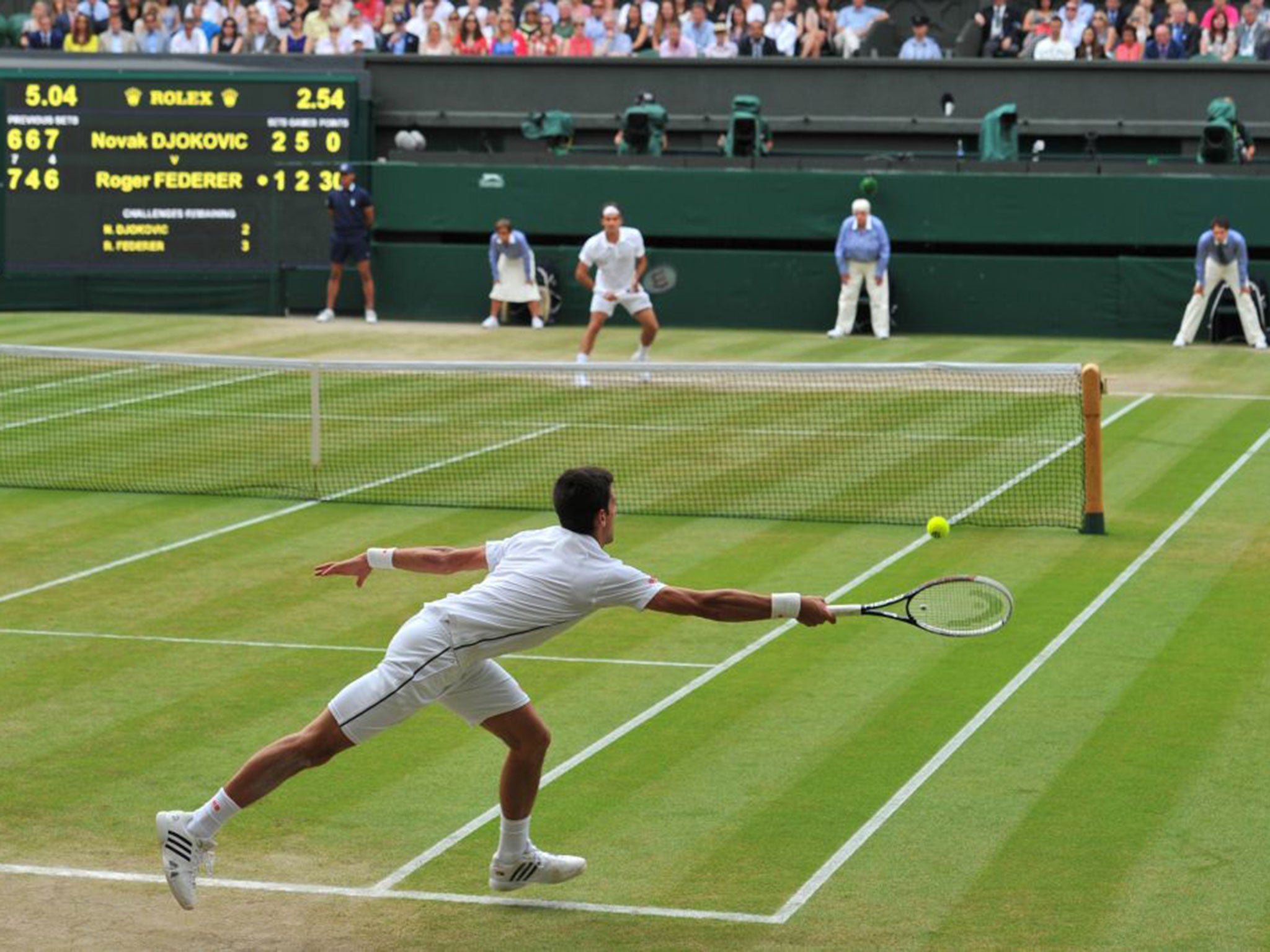 Serbia's Novak Djokovic returns to Switzerland's Roger Federer during their men's singles final match on day thirteen of the 2014 Wimbledon Championships at The All England Tennis Club in Wimbledon,