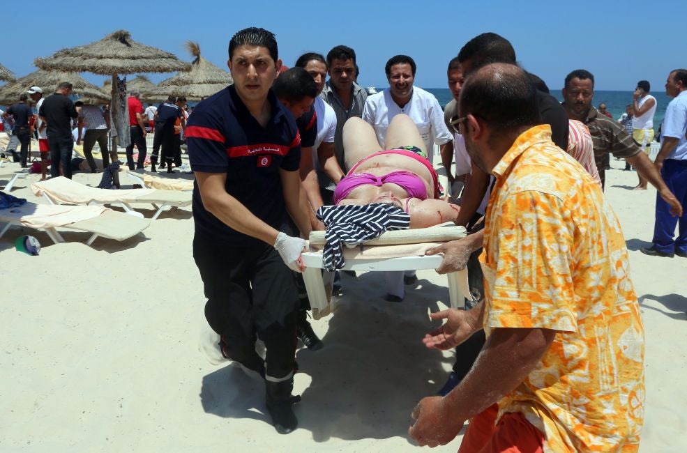 A woman injured in the attack at Sousse is carried from the beach