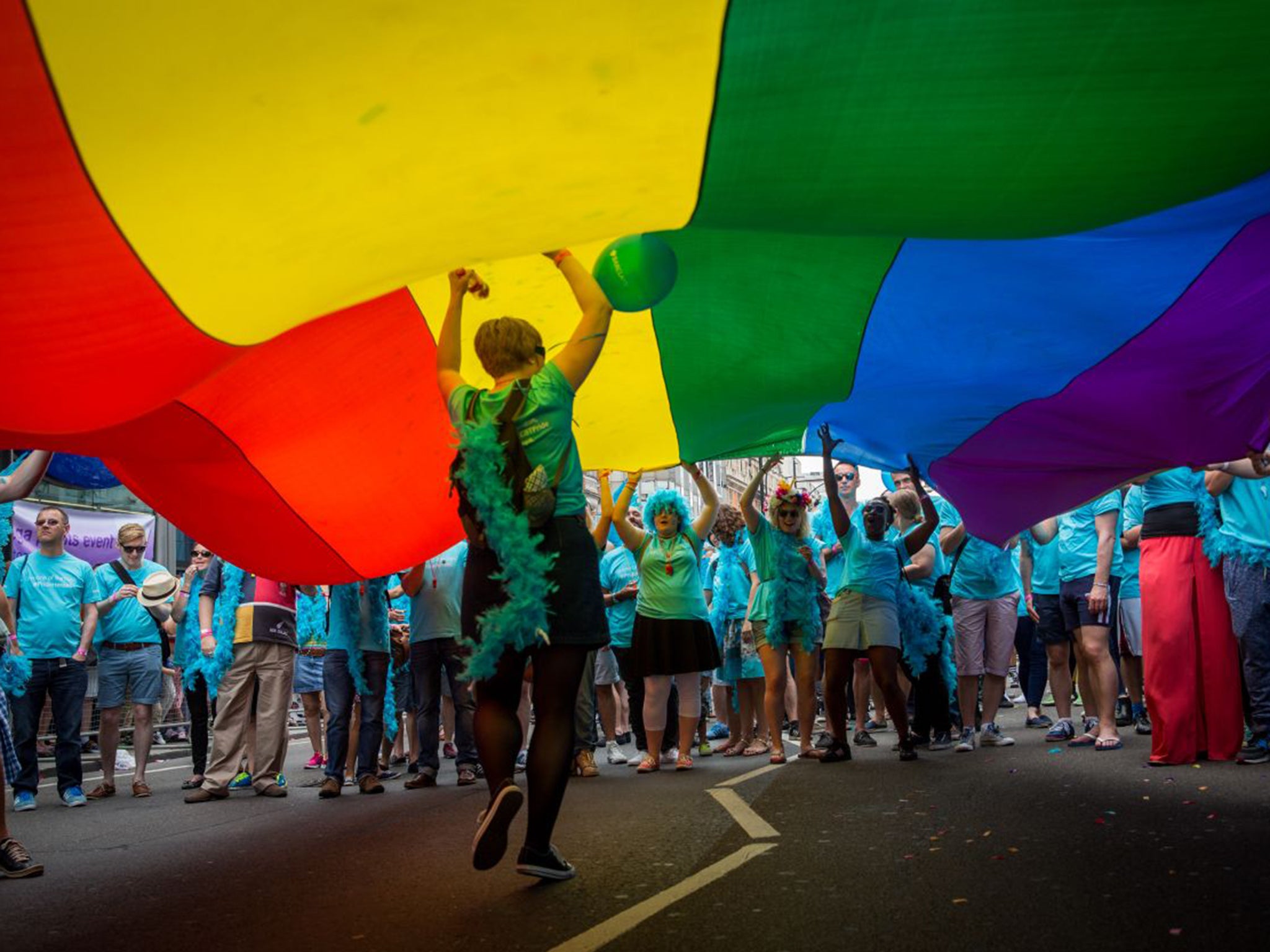 Participants hold up a giant rainbow flag on the parade route from Baker Street to Whitehall