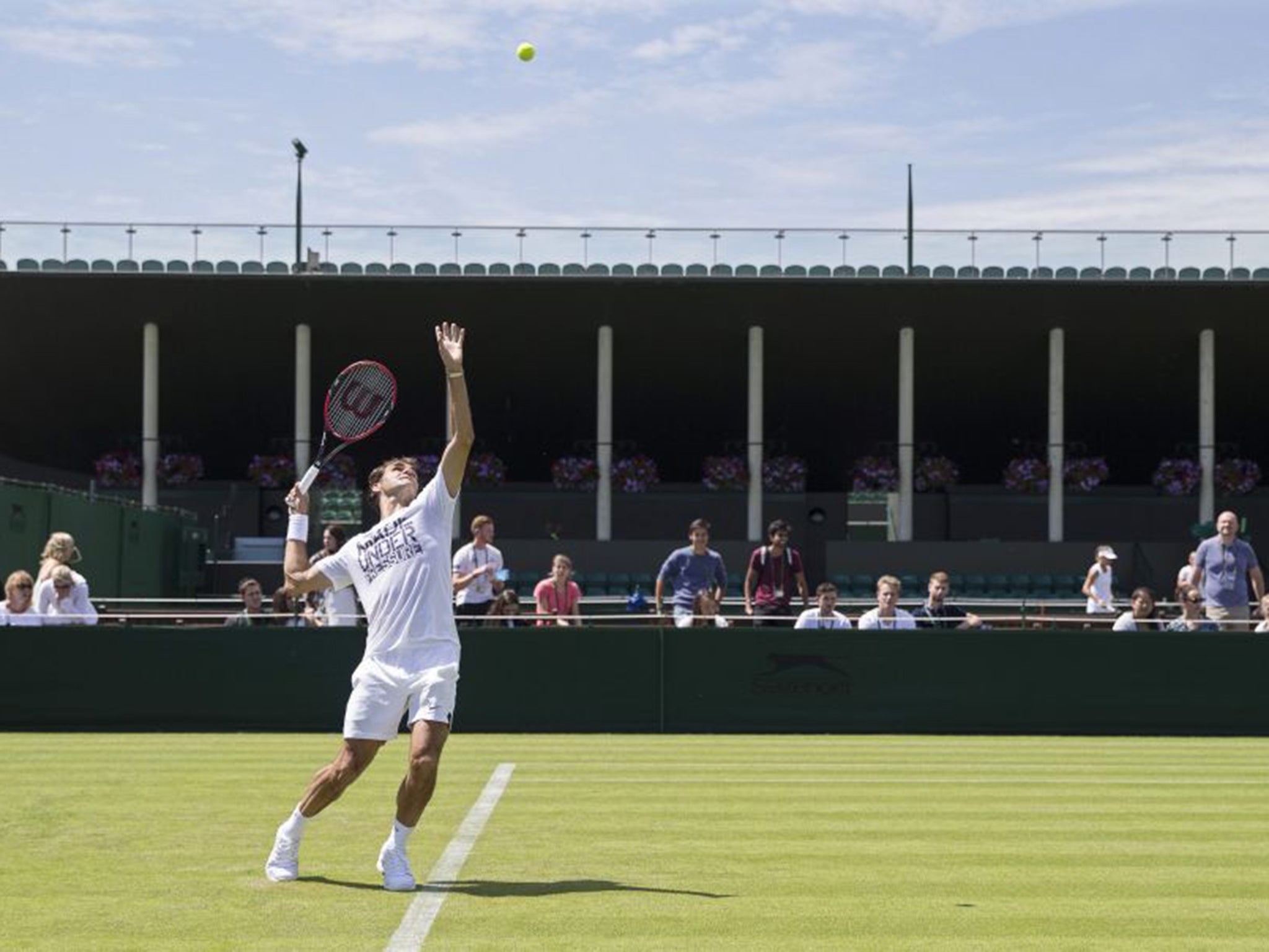 Reaching for the heights: Roger Federer gets in some late practice on Saturday