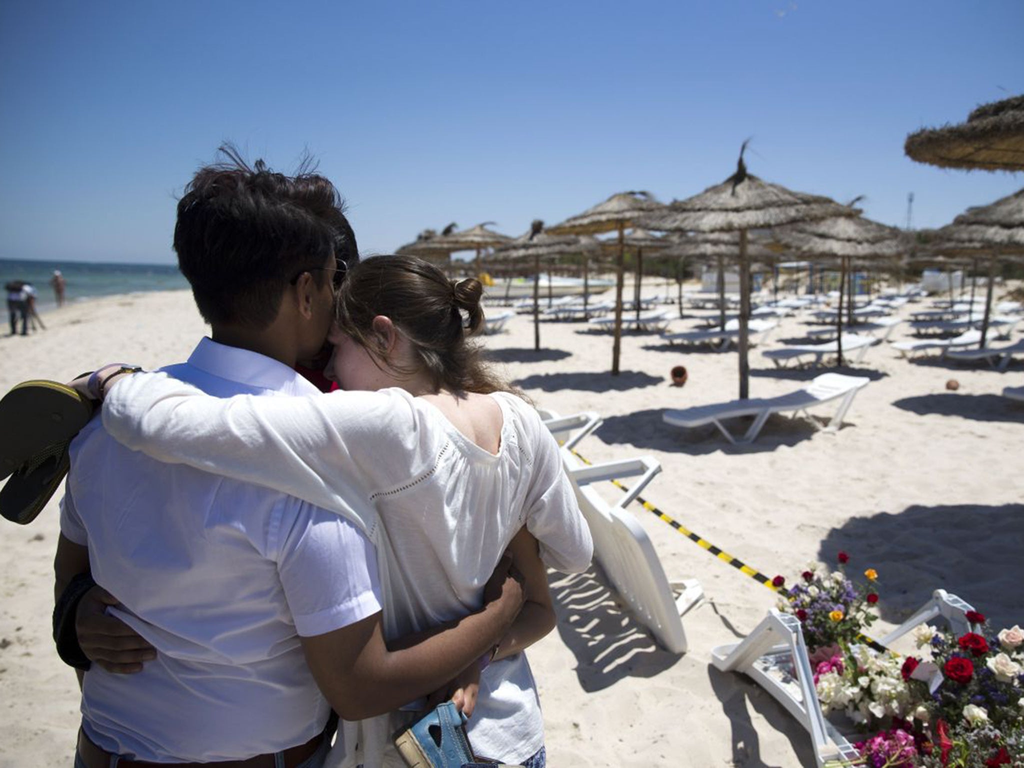 People grieve on the beach in front of the Marhaba Hotel. The families of victims of the attack will be helped with repatriation and locating loved ones