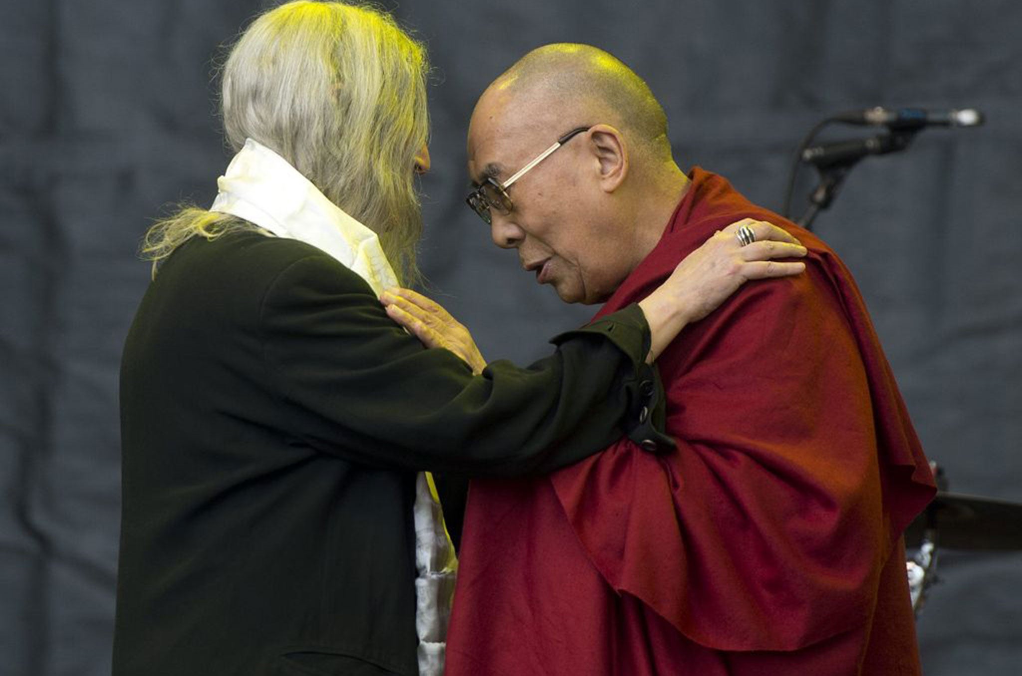 Tibetan spiritual leader, the Dalai Lama (R) joins US singer-songwriter Patti Smith (L) on The Pyramid Stage during her performance on the fifth day of Glastonbury Festival