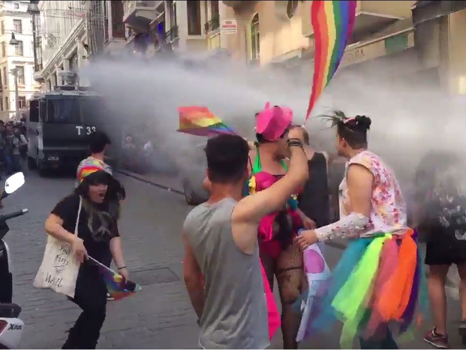 Revellers are blasted by water canons as the dance in the street