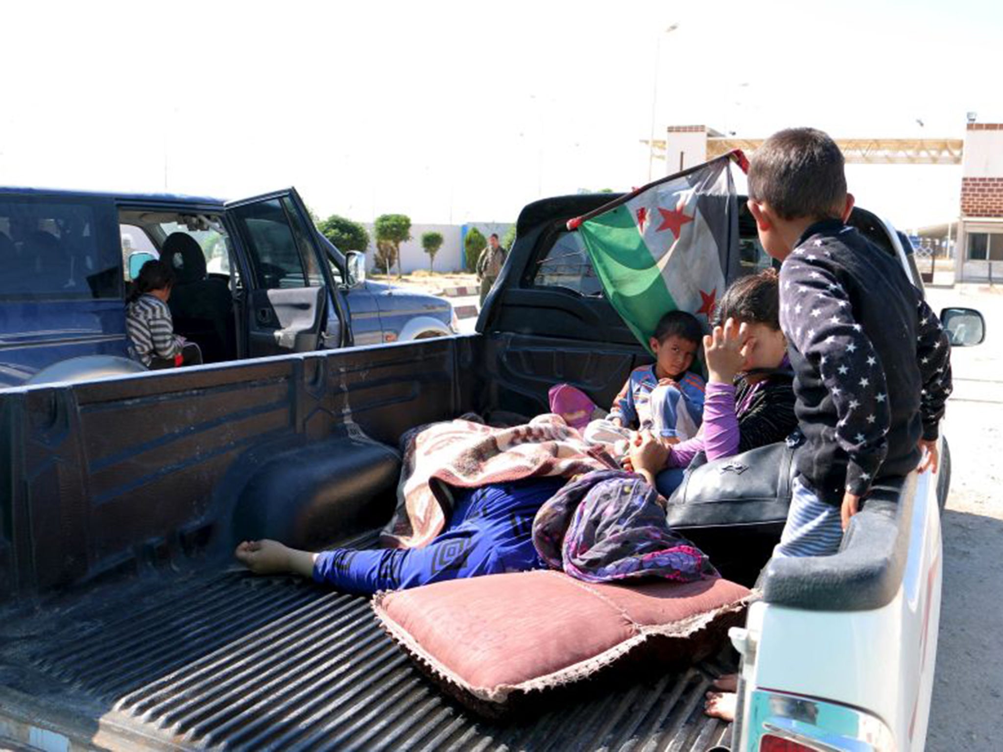 Civilians wounded in Kobani by Isis wait at the Syrian-Turkish border to take refuge