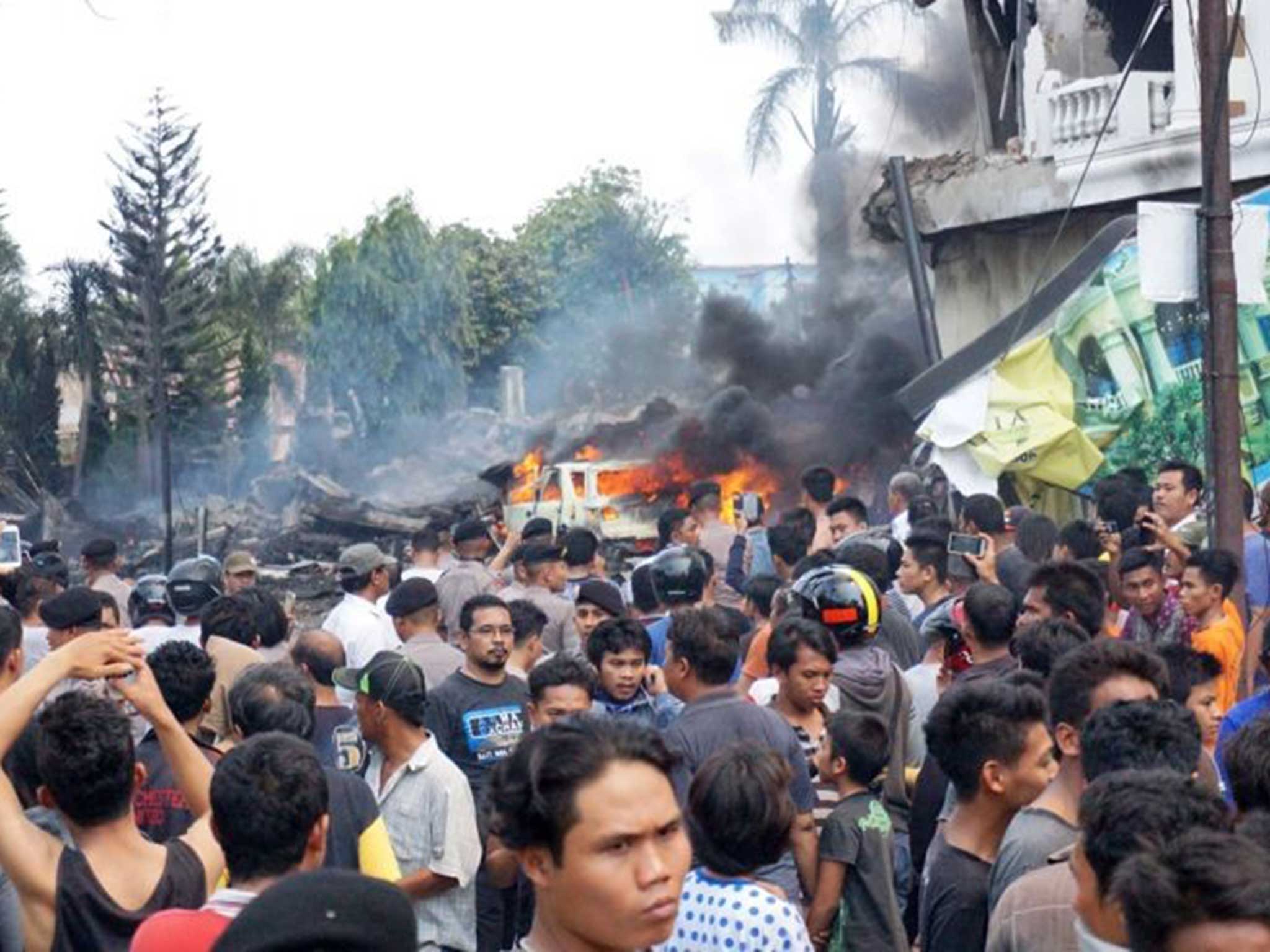 Crowds gather around the debris caused by the crash