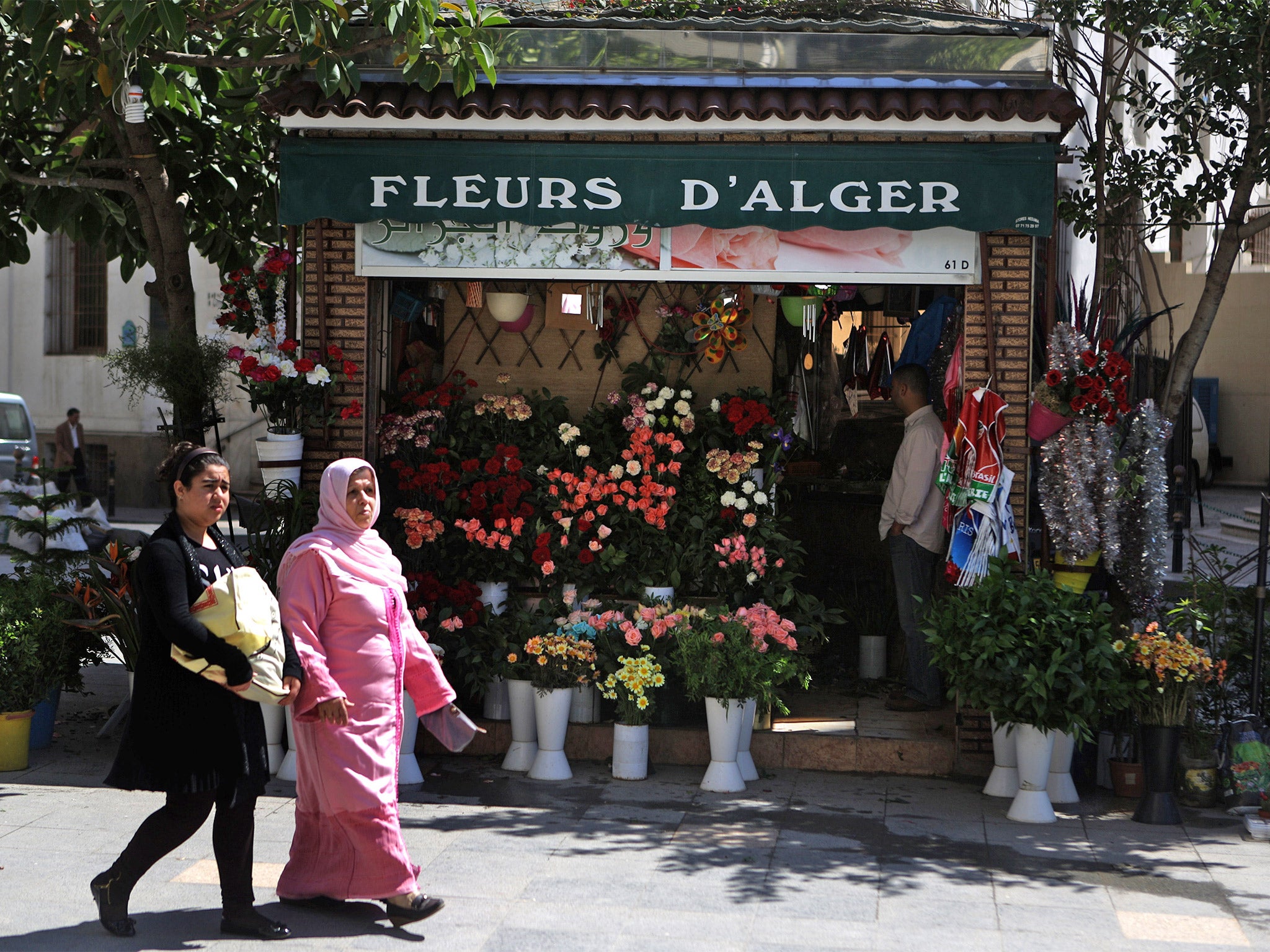 A women walk past a flower shop in the capital city of Algiers (Getty)