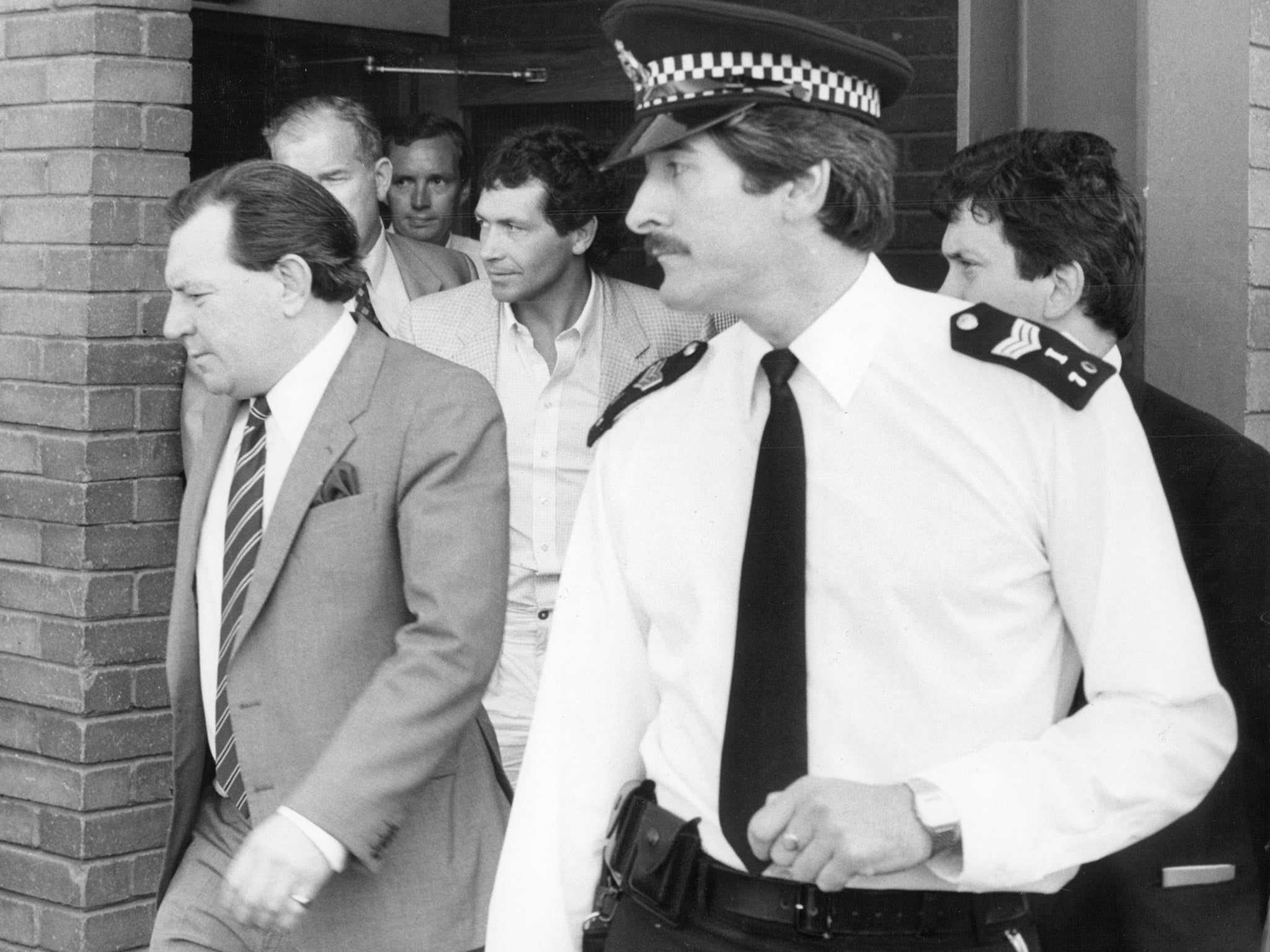 John Palmer surrounded by police as he is arrested in connection with the Brink’s-MAT bullion raid at Heathrow airport, in 1983 (Rex)