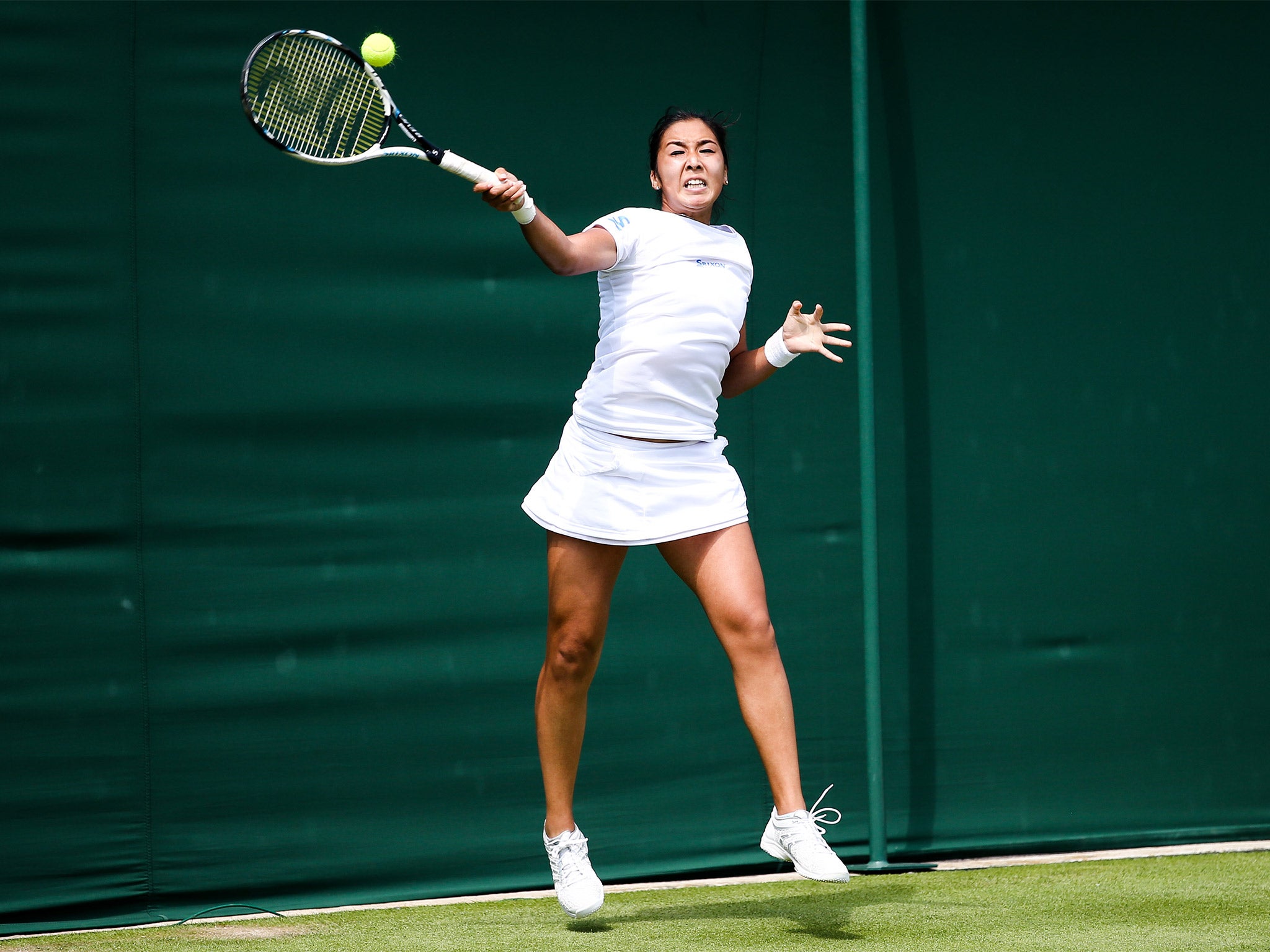 Zarina Diyas plays a high forehand en route to her straight sets victory