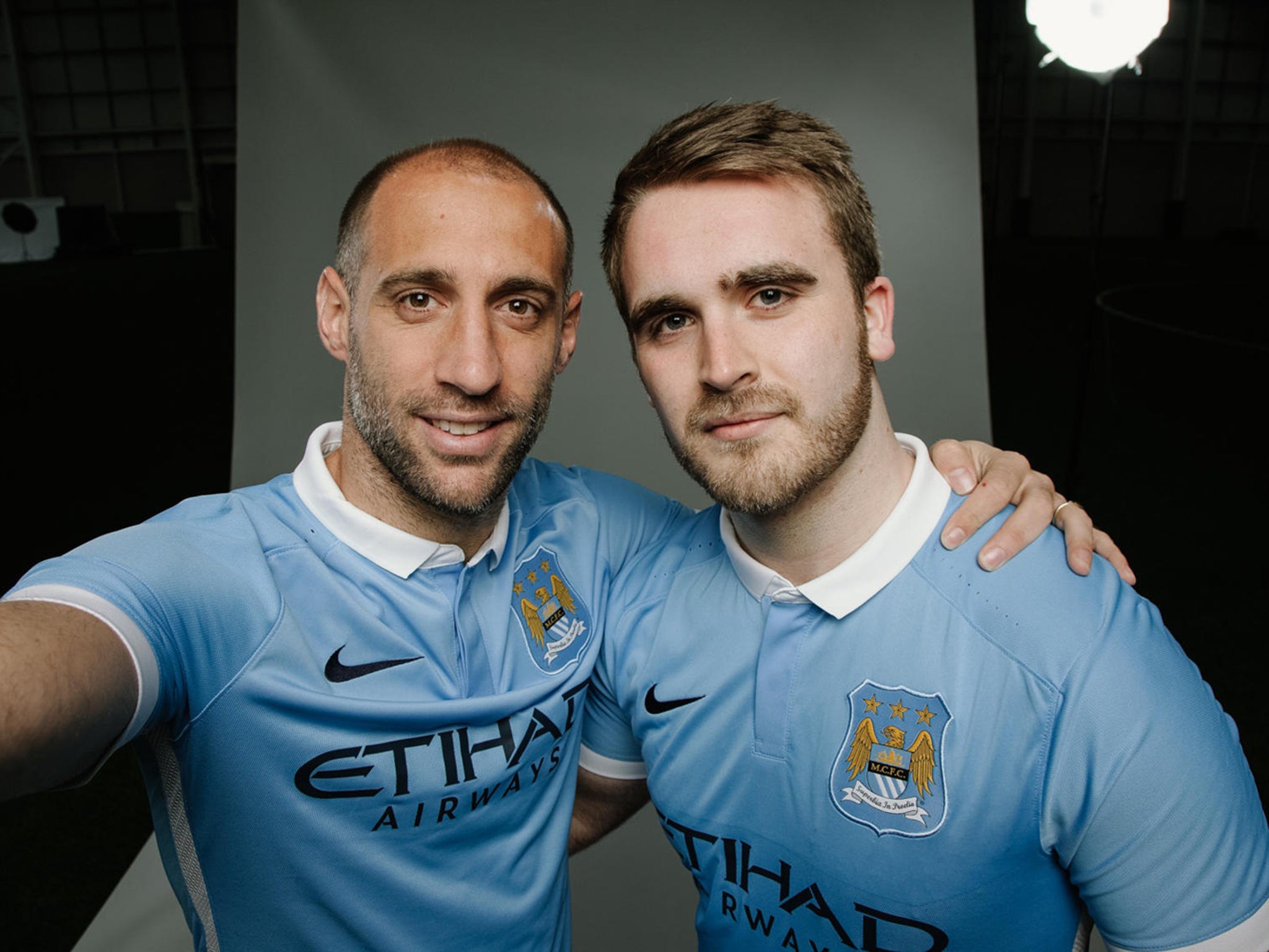 Pablo Zabaleta poses in the new kit with a City supporter