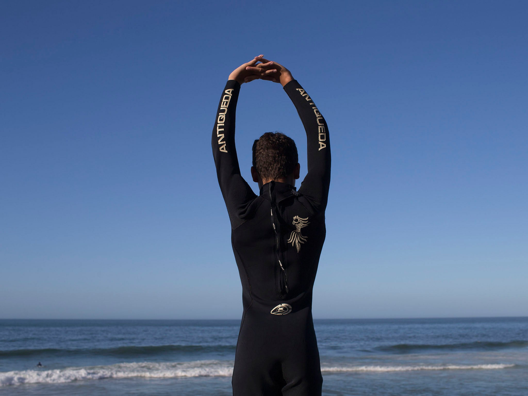 In this photo, Gabriel de Lima, 13, stretches before surfing at Sao Conrado beach in Rio de Janeiro, Brazil. Not long ago, many of these kids were begging on the streets or engaged in crime, but two surf schools serving youth from Rioís largest slum, Roci