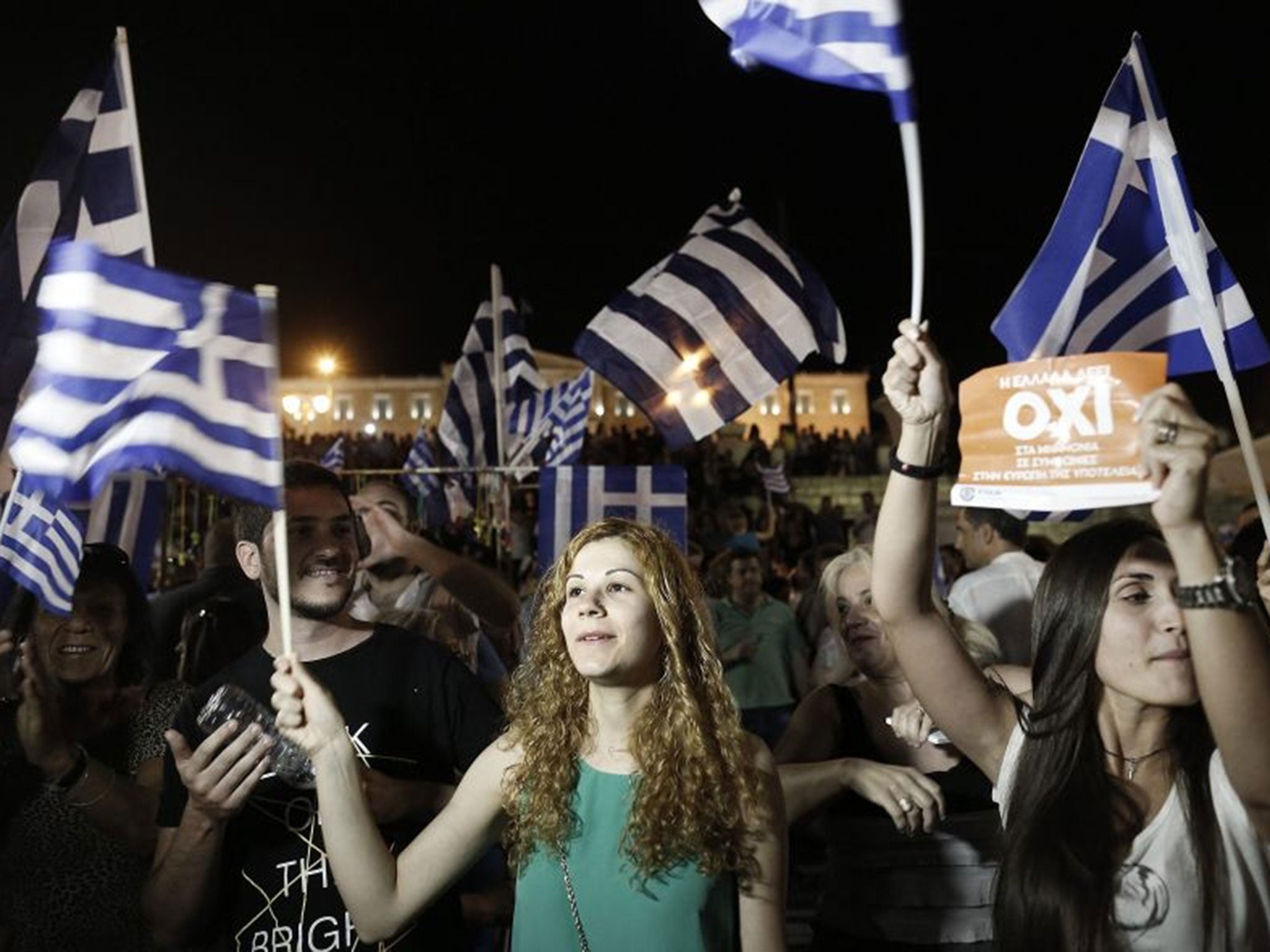 epa04832814 Supporters of the 'No' campaign wave flags and react after the first results of the referendum at Syntagma Square, in Athens, Greece, 05 July 2015. Greek voters in the referendum were asked whether the country should accept reform proposals ma