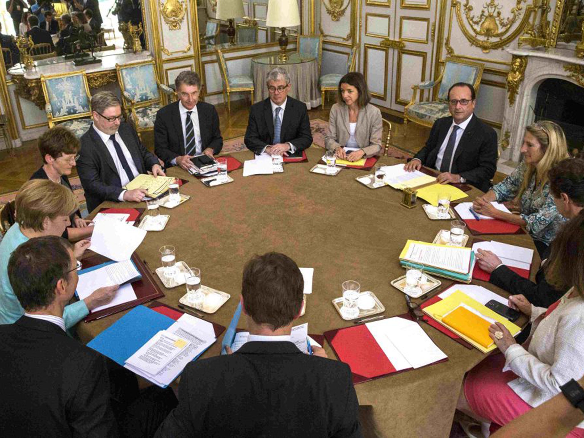 French President Francois Hollande, right, meets German Chancellor Angela Merkel, left, at the Elysee Palace in Paris following the Greek people's resounding 'No' in the referendum