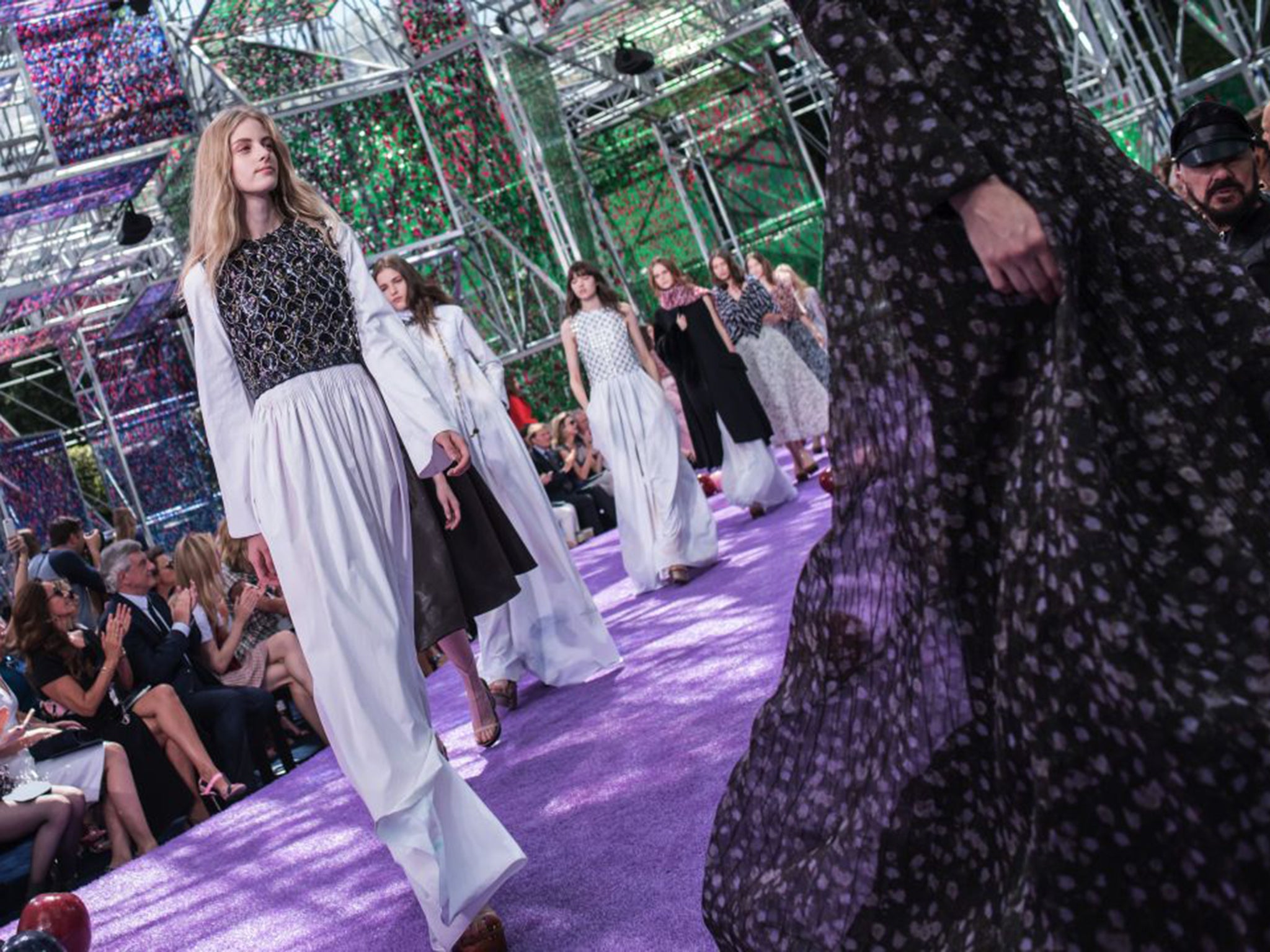 Raf Simons’ Dior models trudged along a narrow lawn of lilac astroturf in garb that seemed from another age