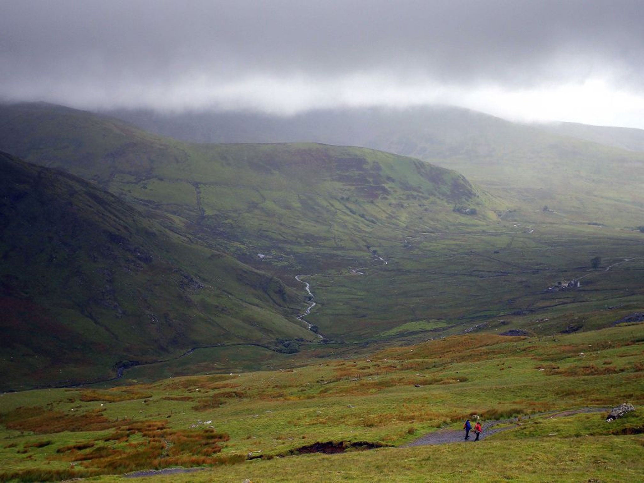 Walkers climb down Mount Snowdon in Snowdonia, north Wales, as two people died after they were hit by lightning while out walking as summer thunderstorms battered Britain.