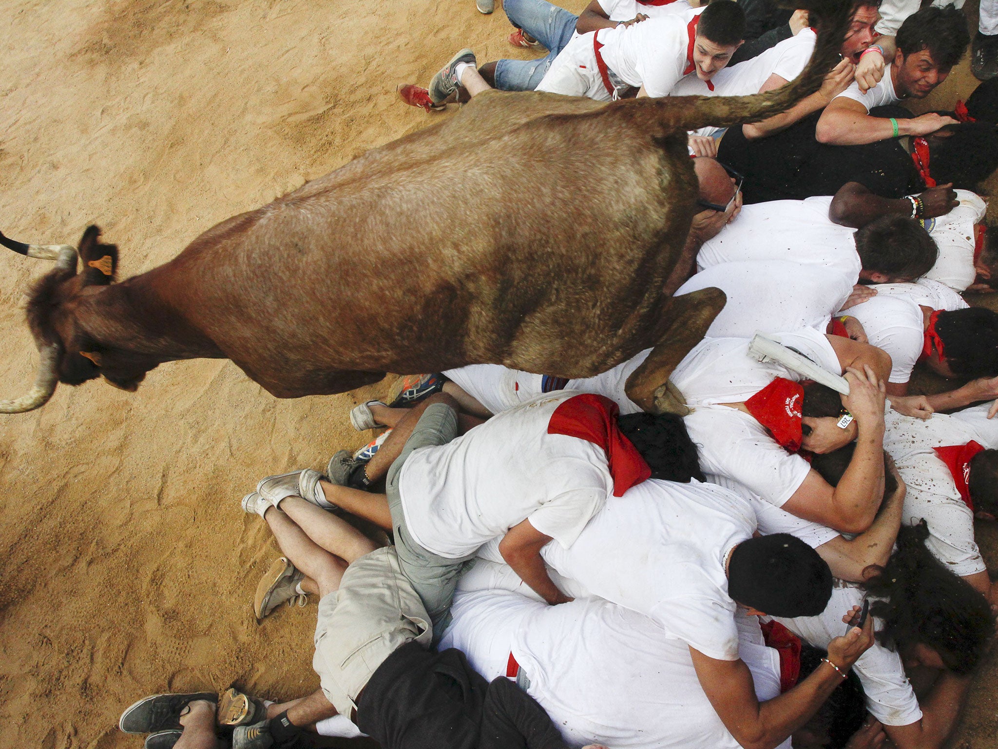 A bull leaps over revellers