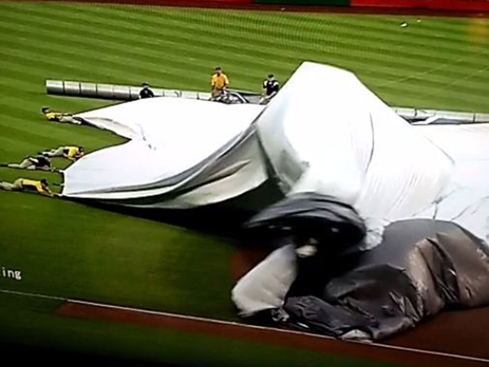 And the groundsman is swept away as the wind catches the tarpaulin