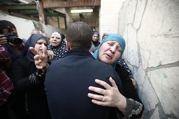 The teen's family are comforted by a relative on the day of his funeral in Ramallah (via Issam Rimawi/Anadolu Agency/Getty Images)