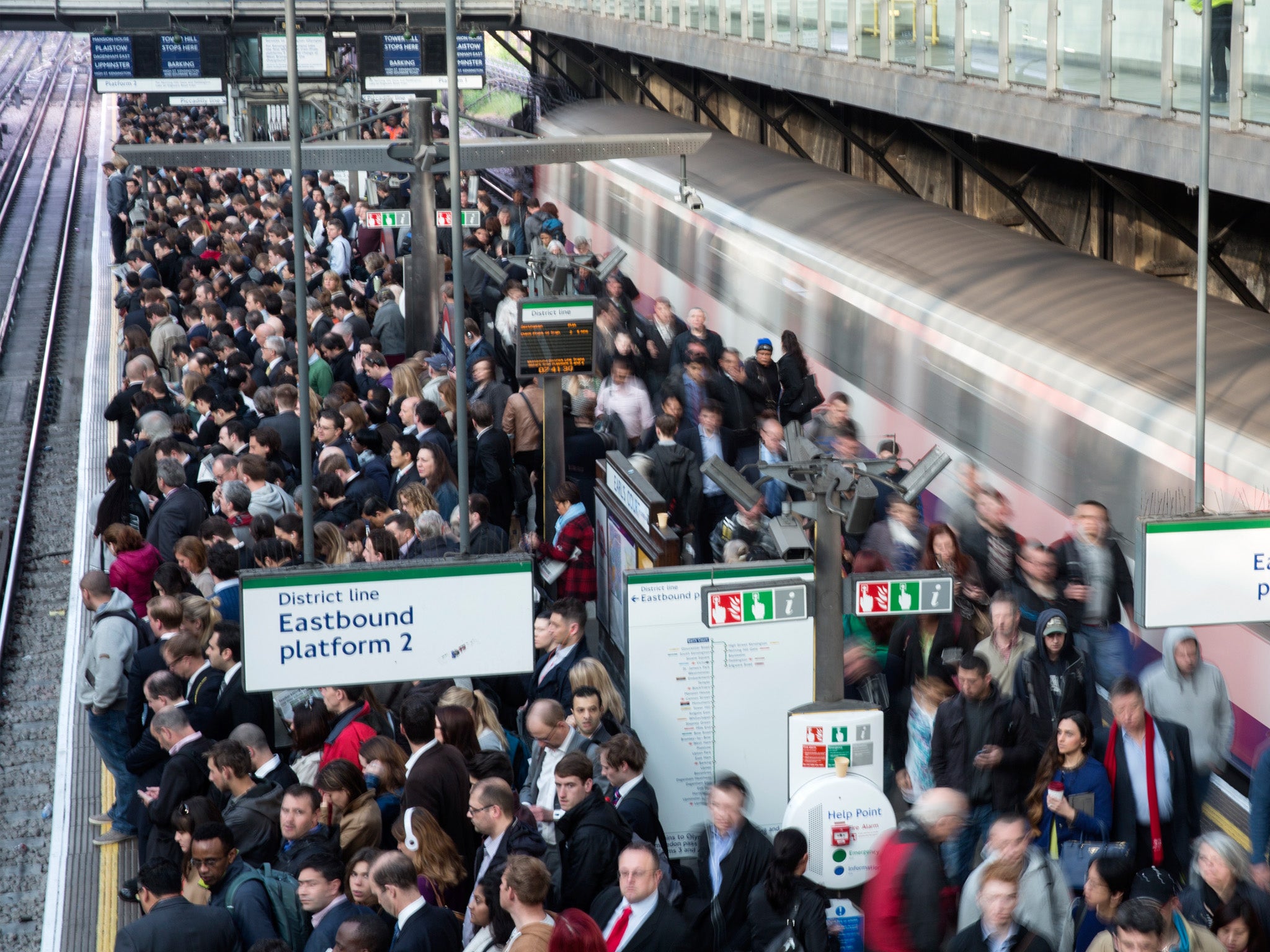 Commuters prepare to travel on the District Line of the London Underground which is running a limited service due to industrial action on 30 April 2014 in London, England