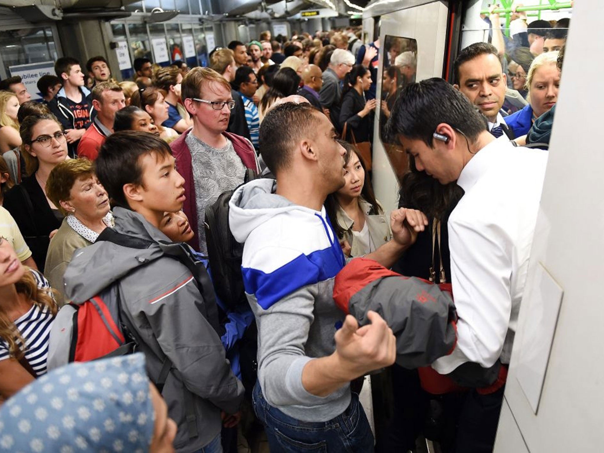 Commuters try to get onto a tube train at Westminster station in London, Britain, 08 July 2015.