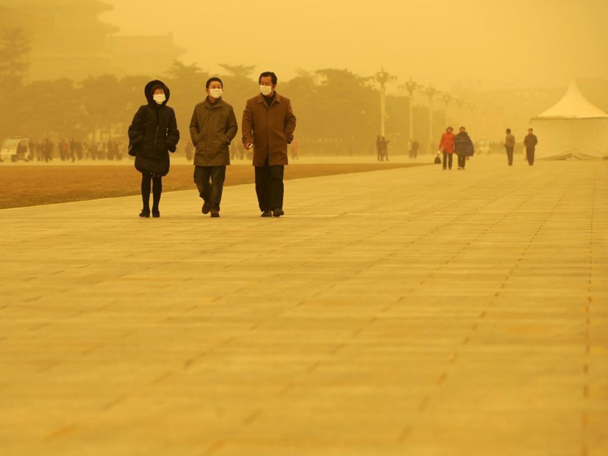 People walk in Tiananmen Square in Beijing, during a sandstorm on 20 March 2010.