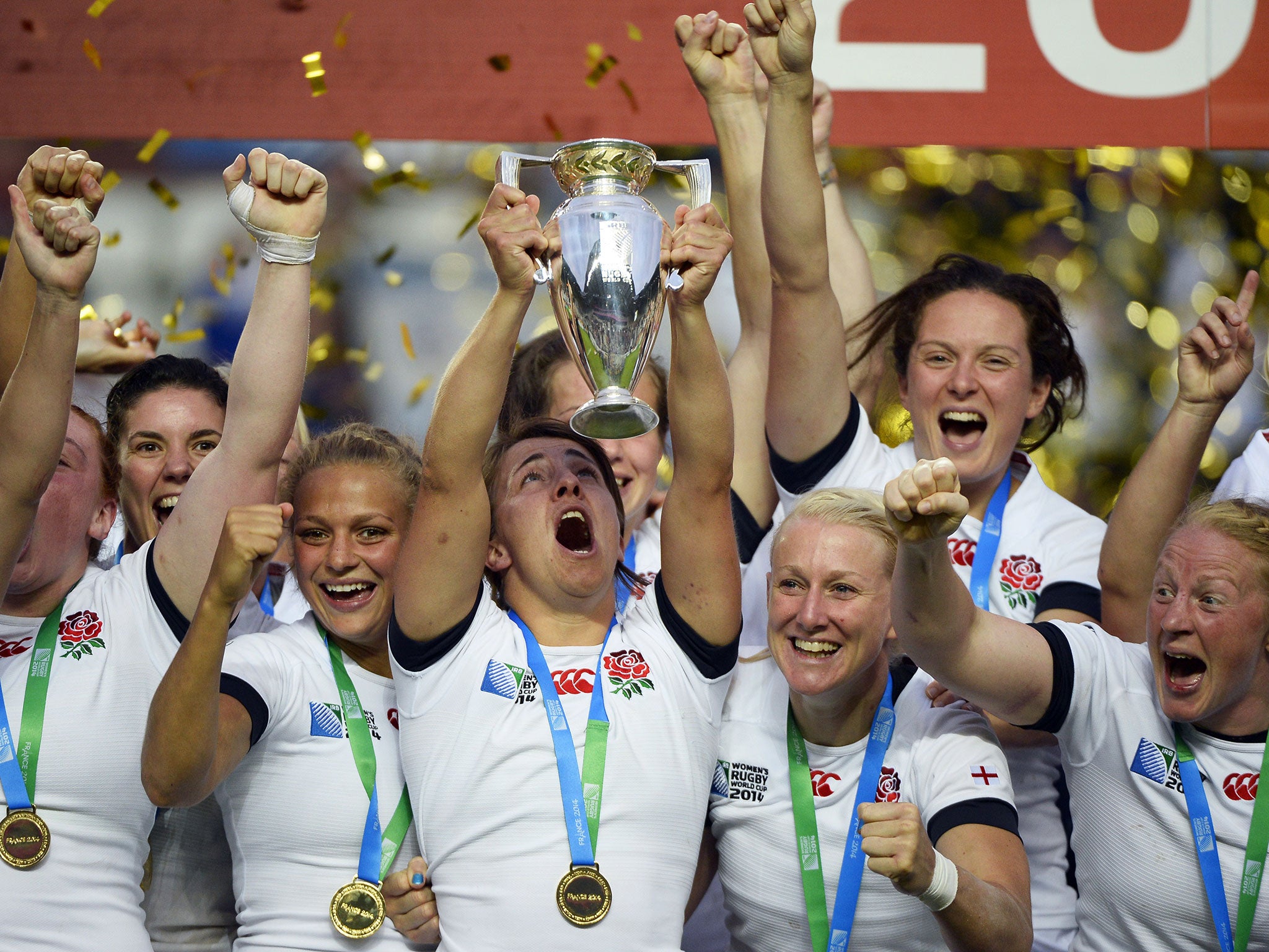 England's players celebrate with the trophy after winning the IRB Women's Rugby World Cup final match between England and Canada