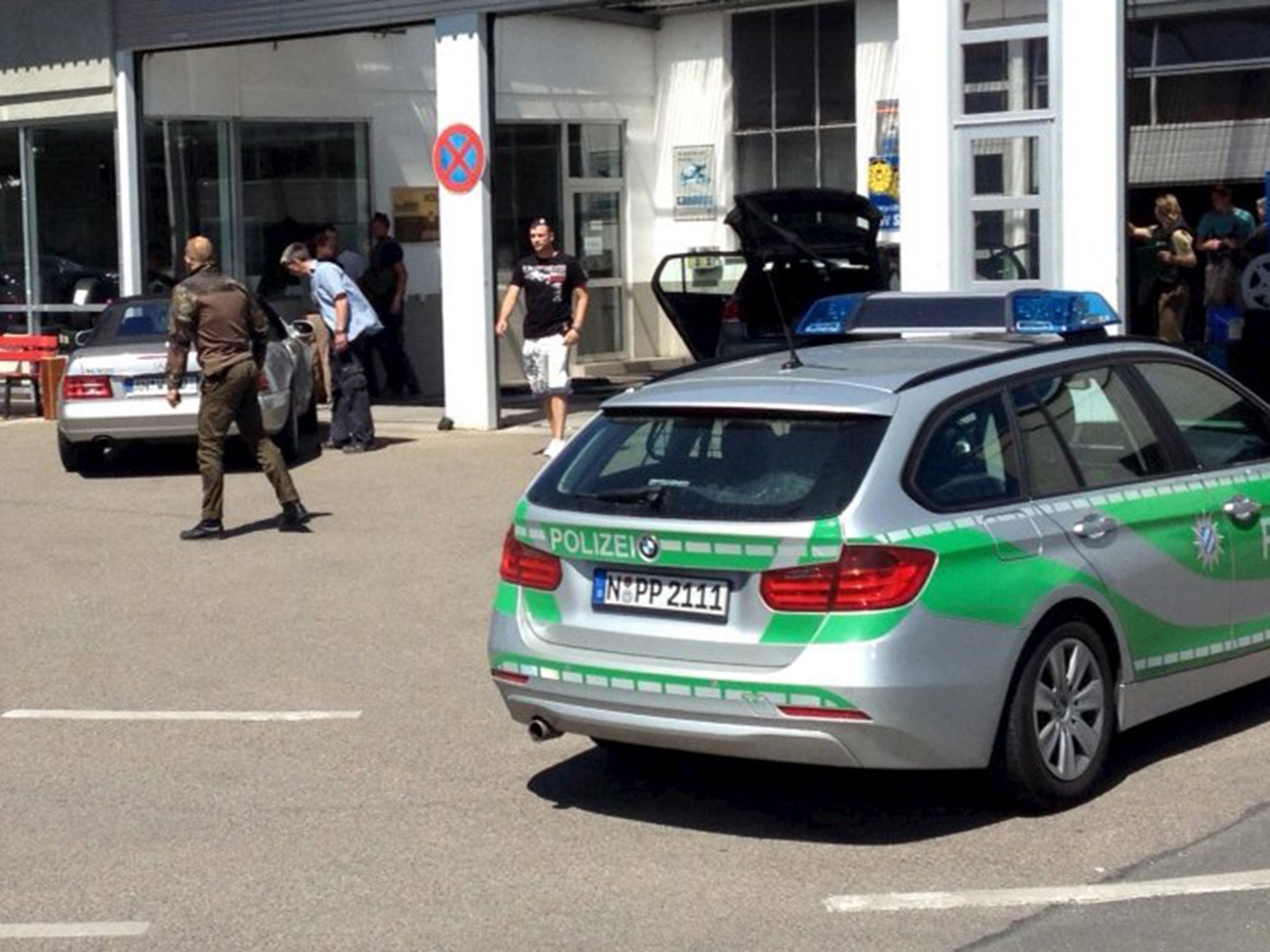 Police vehicles block a car at a petrol station in Bad Windsheim, Germany. German police said they have arrested a man suspected of shooting dead two people near Ansbach in northern Bavaria