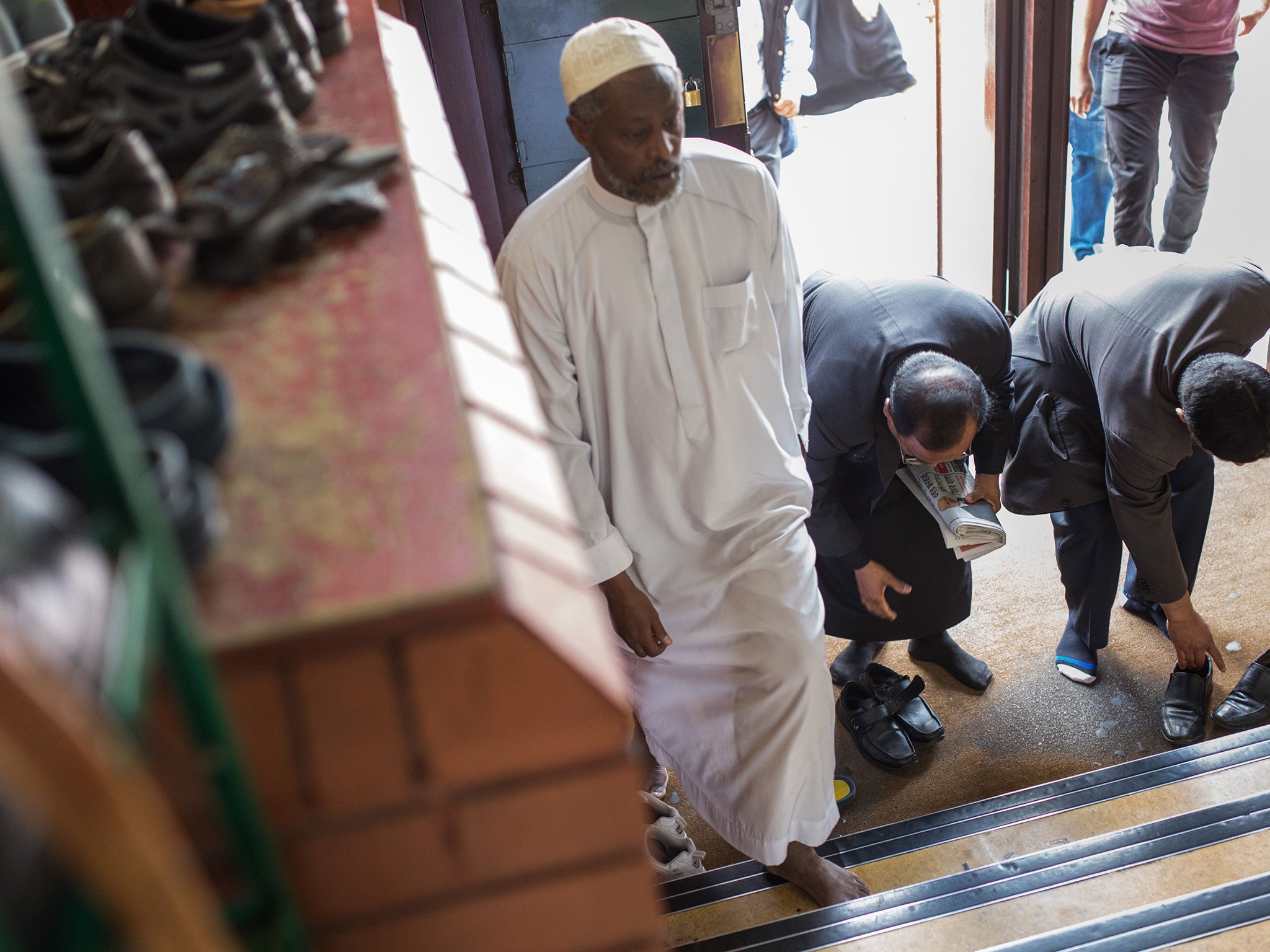 Men arrive at the East London Mosque to attend the first Friday prayers of the Islamic holy month of Ramadan on June 19, 2015 in London