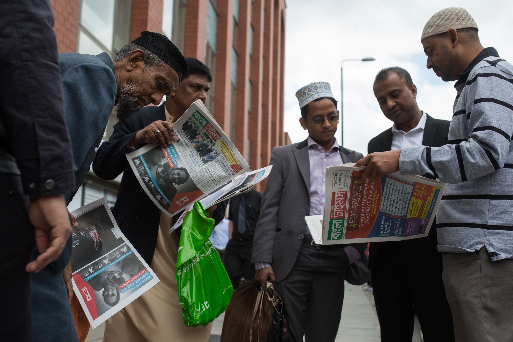 Men read newspapers outside the East London Mosque