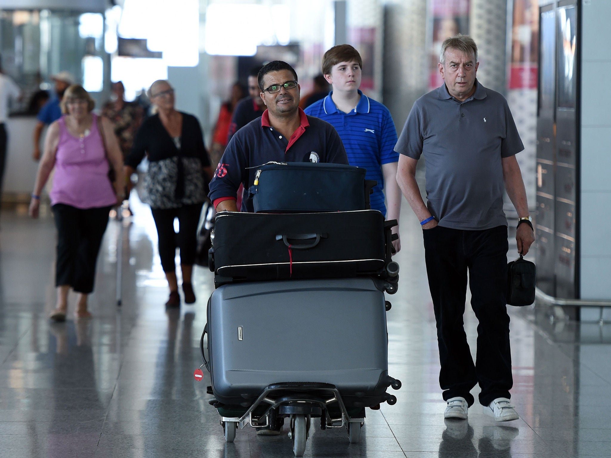 Tourists arrive back in the UK from Tunisia