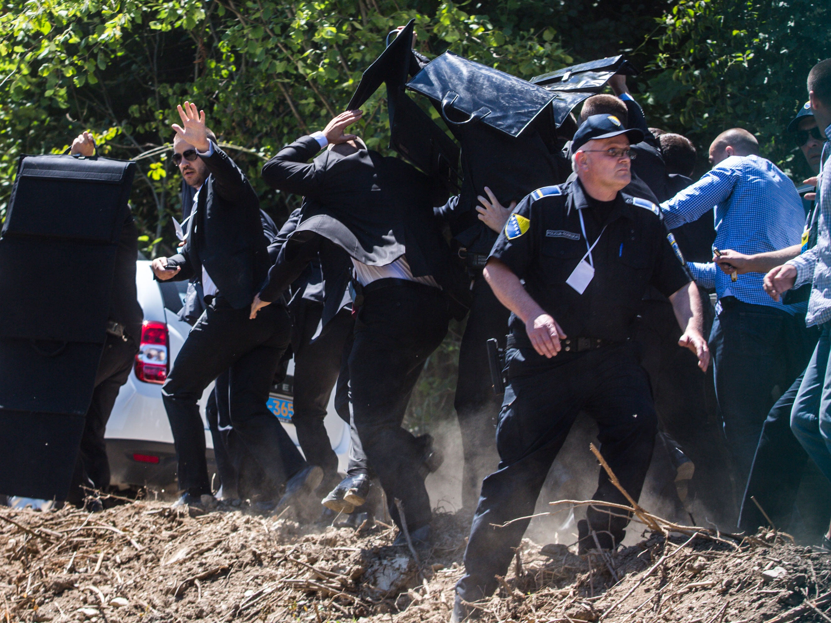 Bodyguards use umbrella and protection to protect Prime Minister of Serbia Aleksandar Vucic