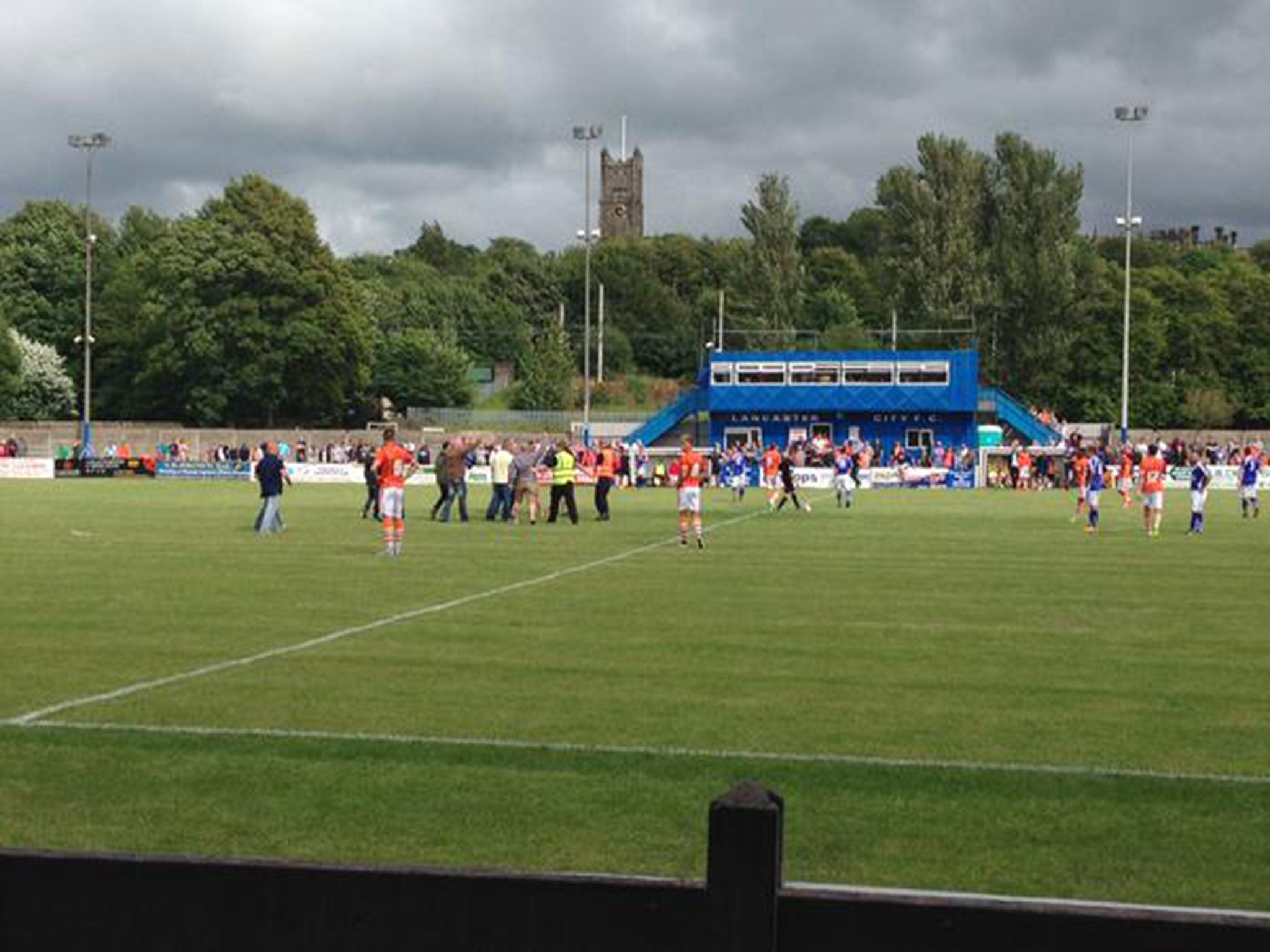 Fans run onto the pitch during the game between Blackpool and Lancaster City