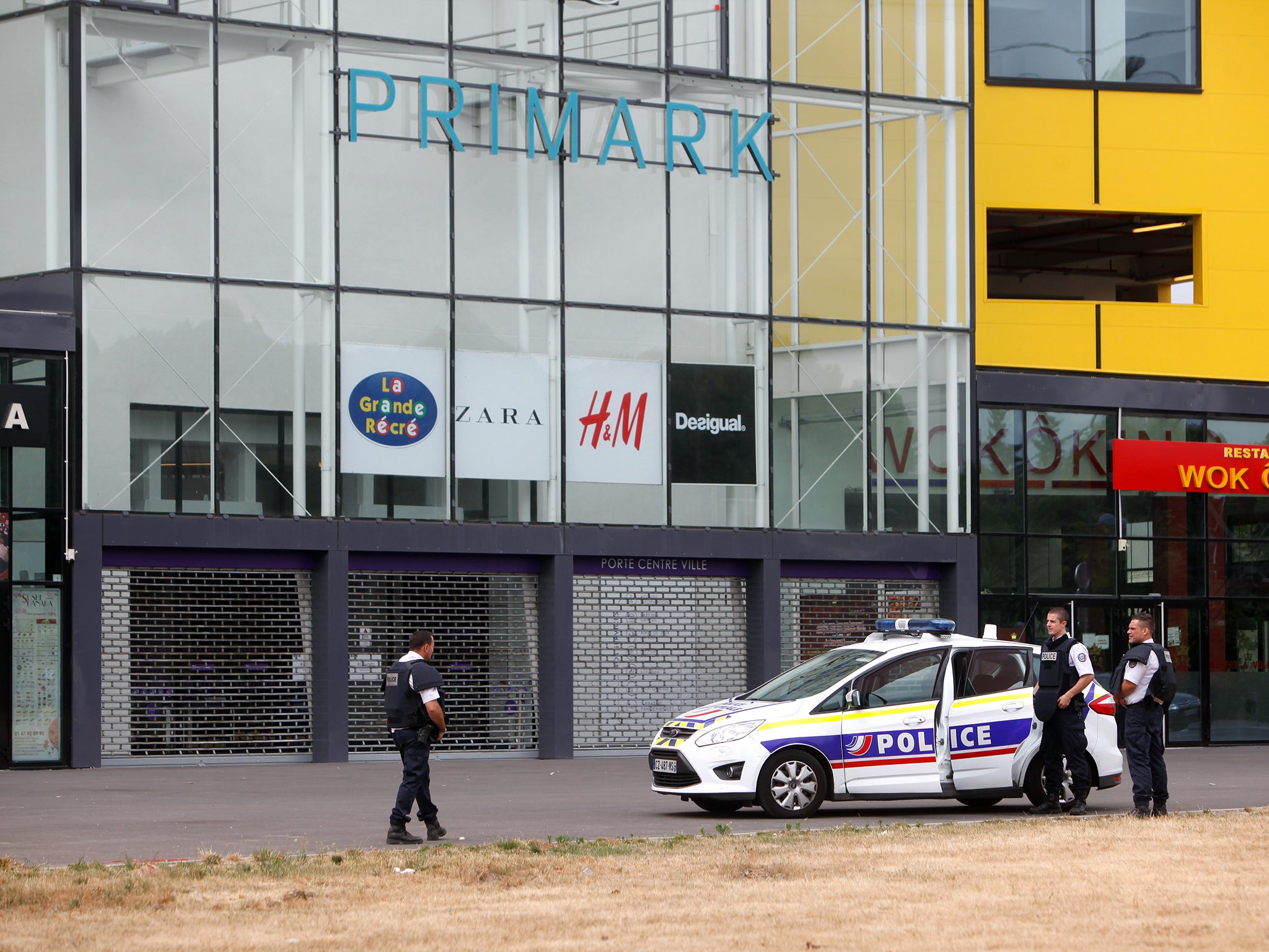 Police officers stand outside a suburban clothing store, in Villeneuve-la-Garenne, north of Paris