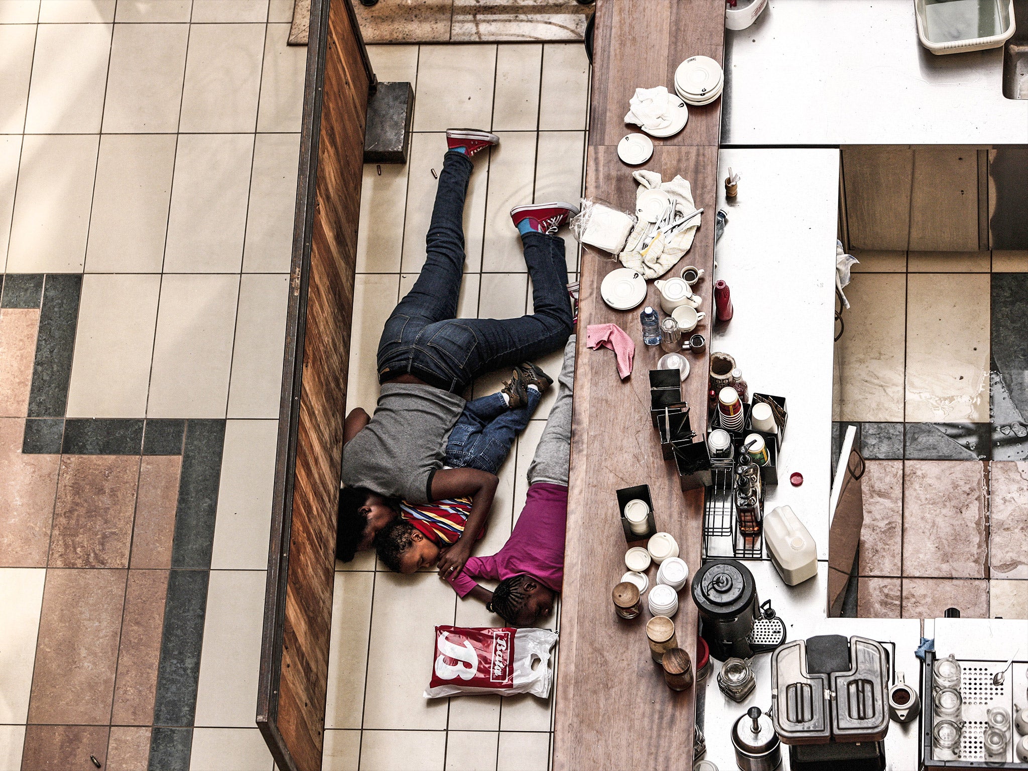 People are seen taking cover behind a counter at the Westgate shopping mall during the 2013 siege