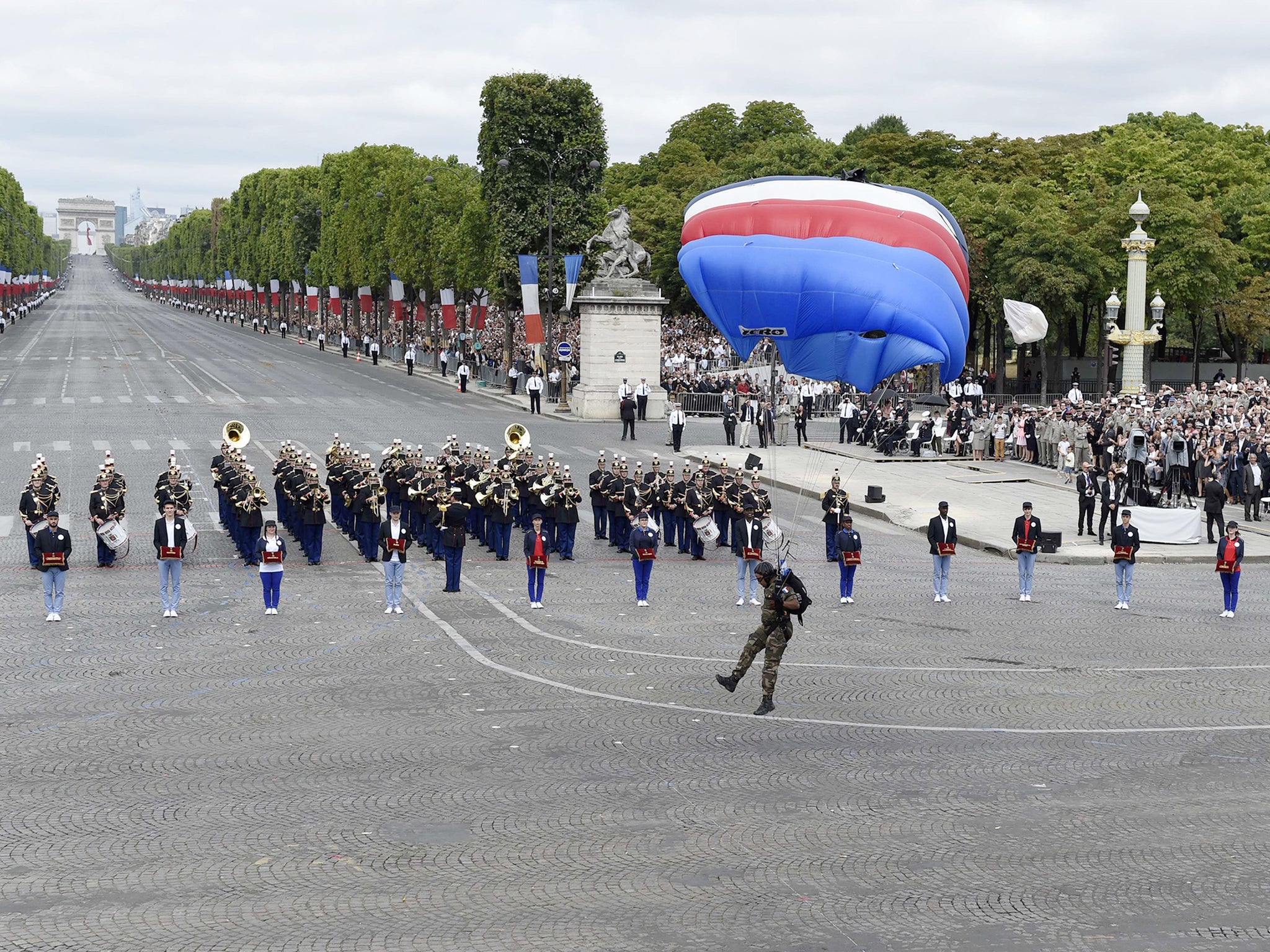 A paratrooper lands during the annual Bastille Day military parade in Paris