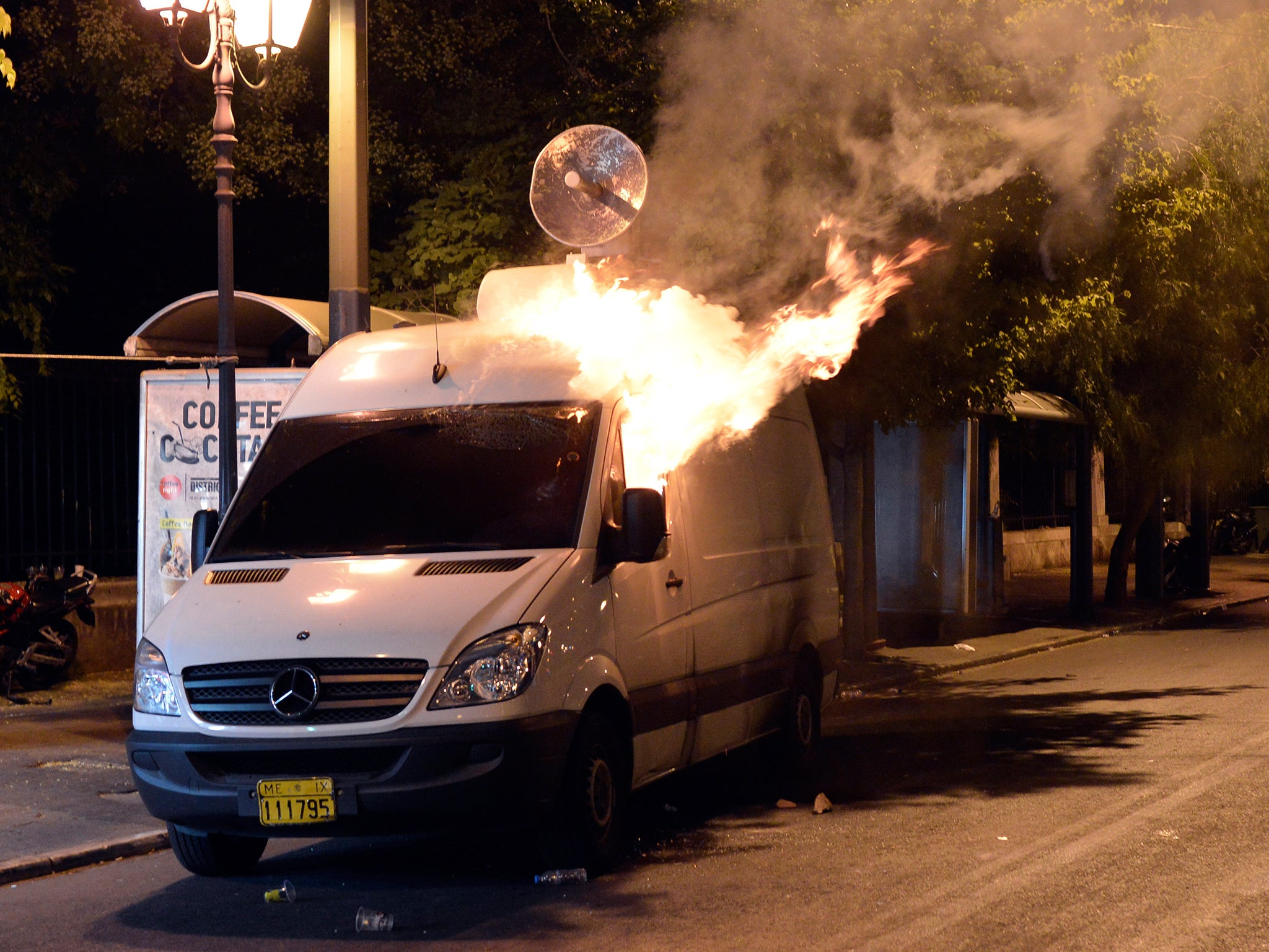 Protesters set fire to a TV van during clashes