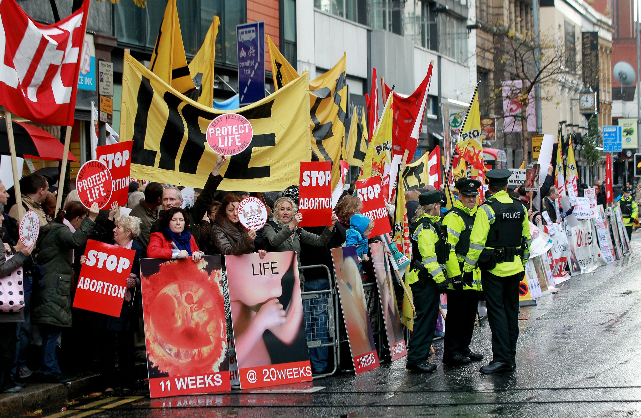 Police walk around abortion protestors holding up placards outside the Marie Stopes clinic, the first private clinic to offer abortions to women in Belfast, Northern Ireland on October 18, 2012.