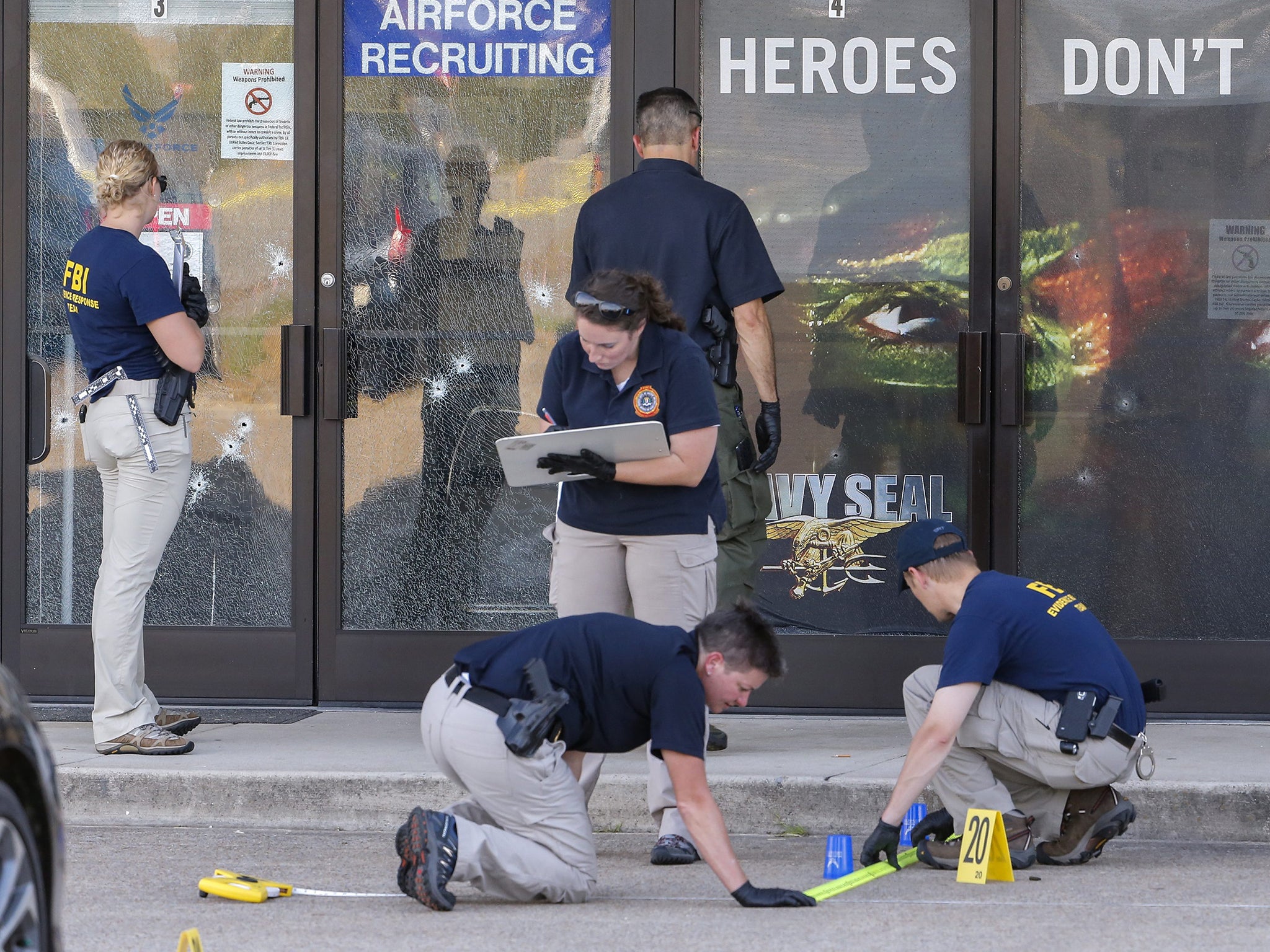 Members of a Federal Bureau of Investigations (FBI) Evidence Response Team work outside a US Military Recruiting storefront after a shooting in Chattanooga