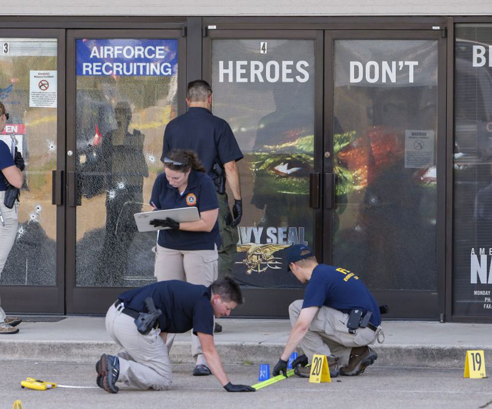 Members of a Federal Bureau of Investigations (FBI) Evidence Response Team work outside a US Military Recruiting after the shooting