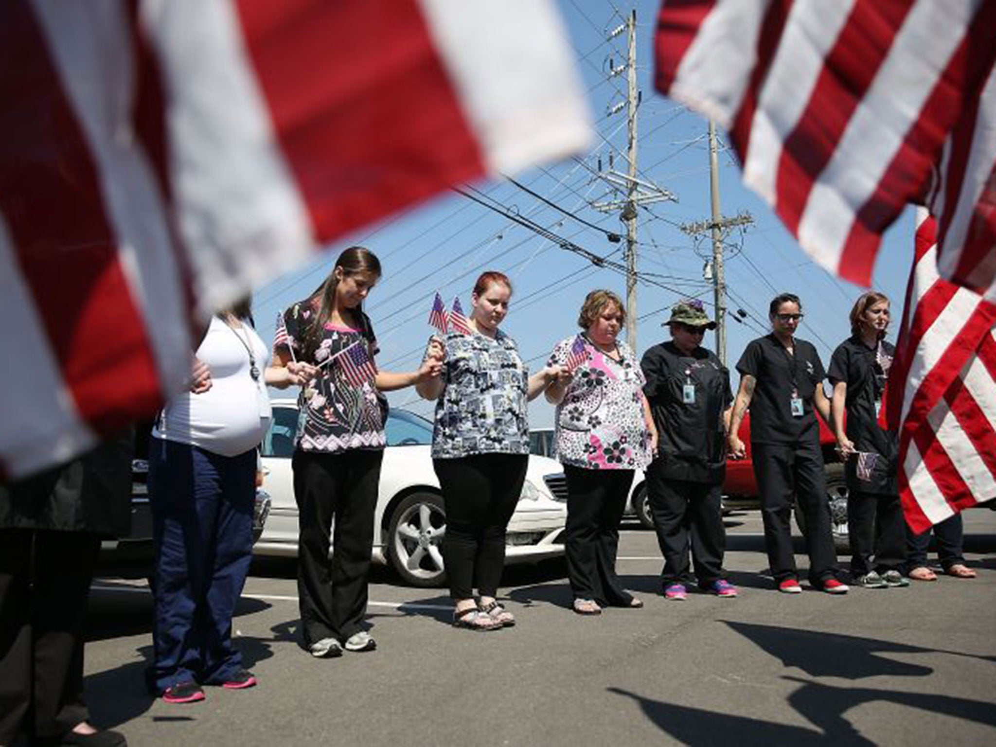 Students and others join in prayer across the highway from where a gunman attacked the Armed Forces Career Center in Chattanooga