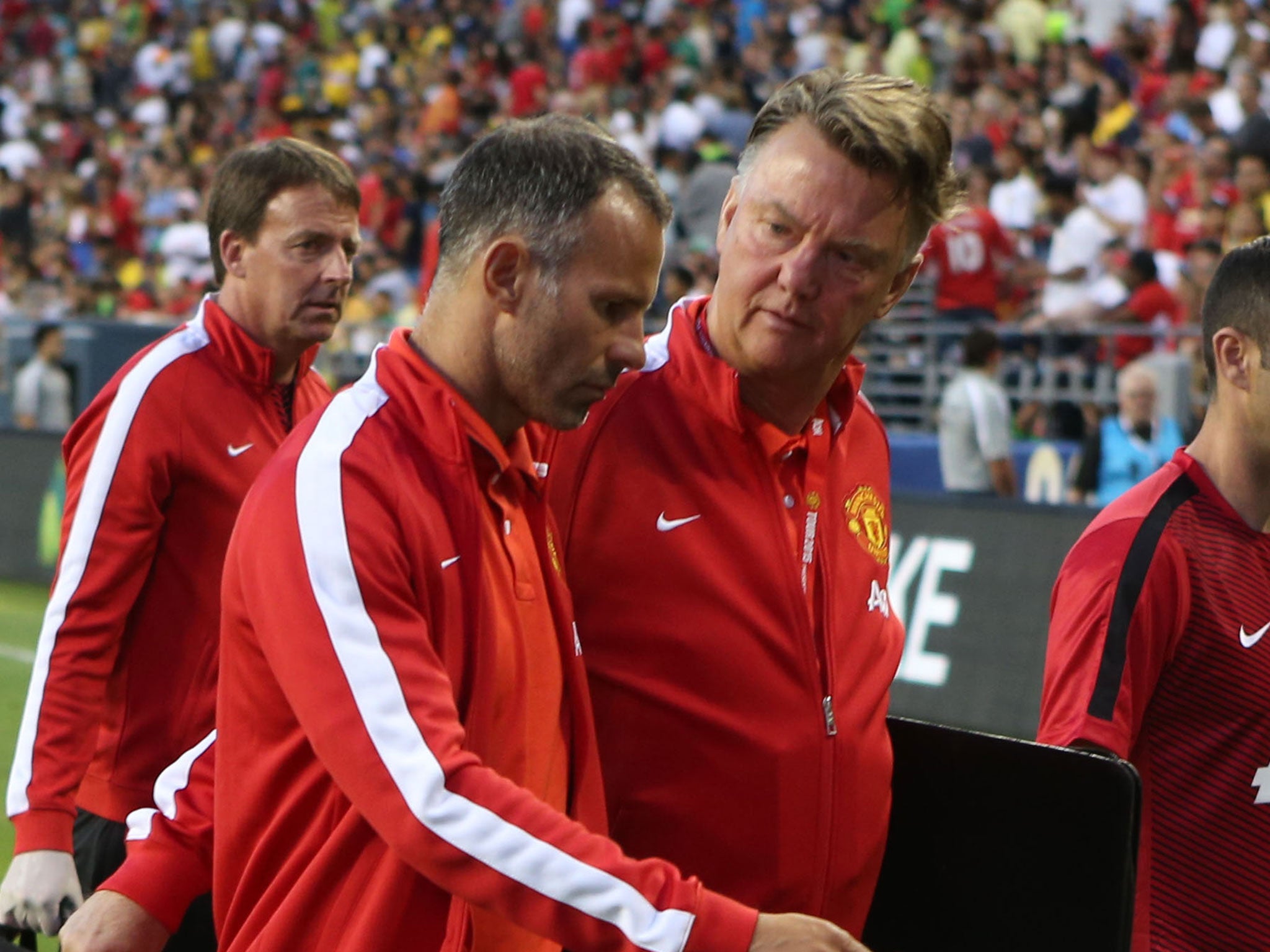 Louis van Gaal speaks with Ryan Giggs as the United staff walk off the pitch