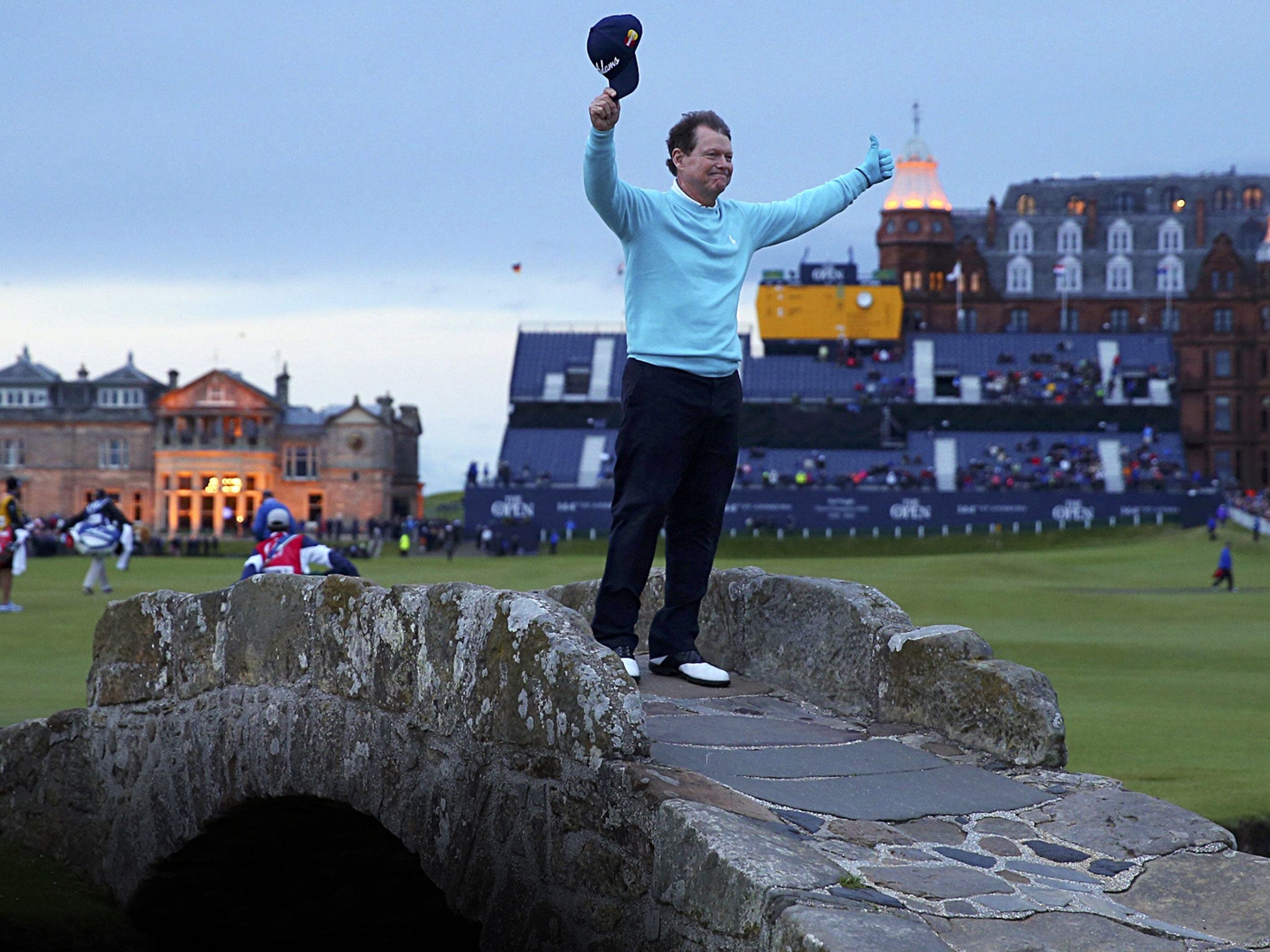 Five-time champion Tom Watson waves a poignant goodbye in the twilight on the Swilcan Bridge