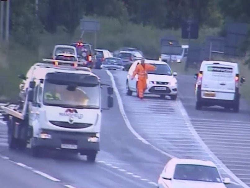 A road safety official stops a van after it u-turned in the wrong direction on to an M1 slip road to avoid a traffic jam