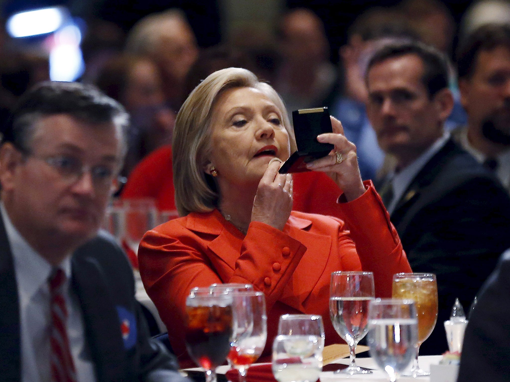 U.S. Democratic presidential candidate Hillary Clinton adjusts her make-up before speaking at the Iowa Democratic Party's Hall of Fame dinner in Cedar Rapids in Iowa