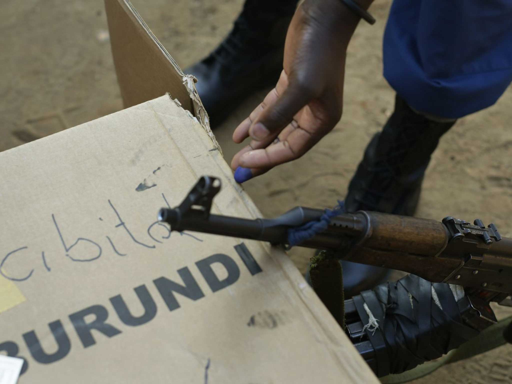 A soldier attempts to rub off the indelible ink after casting his vote in Burundi's presidential election