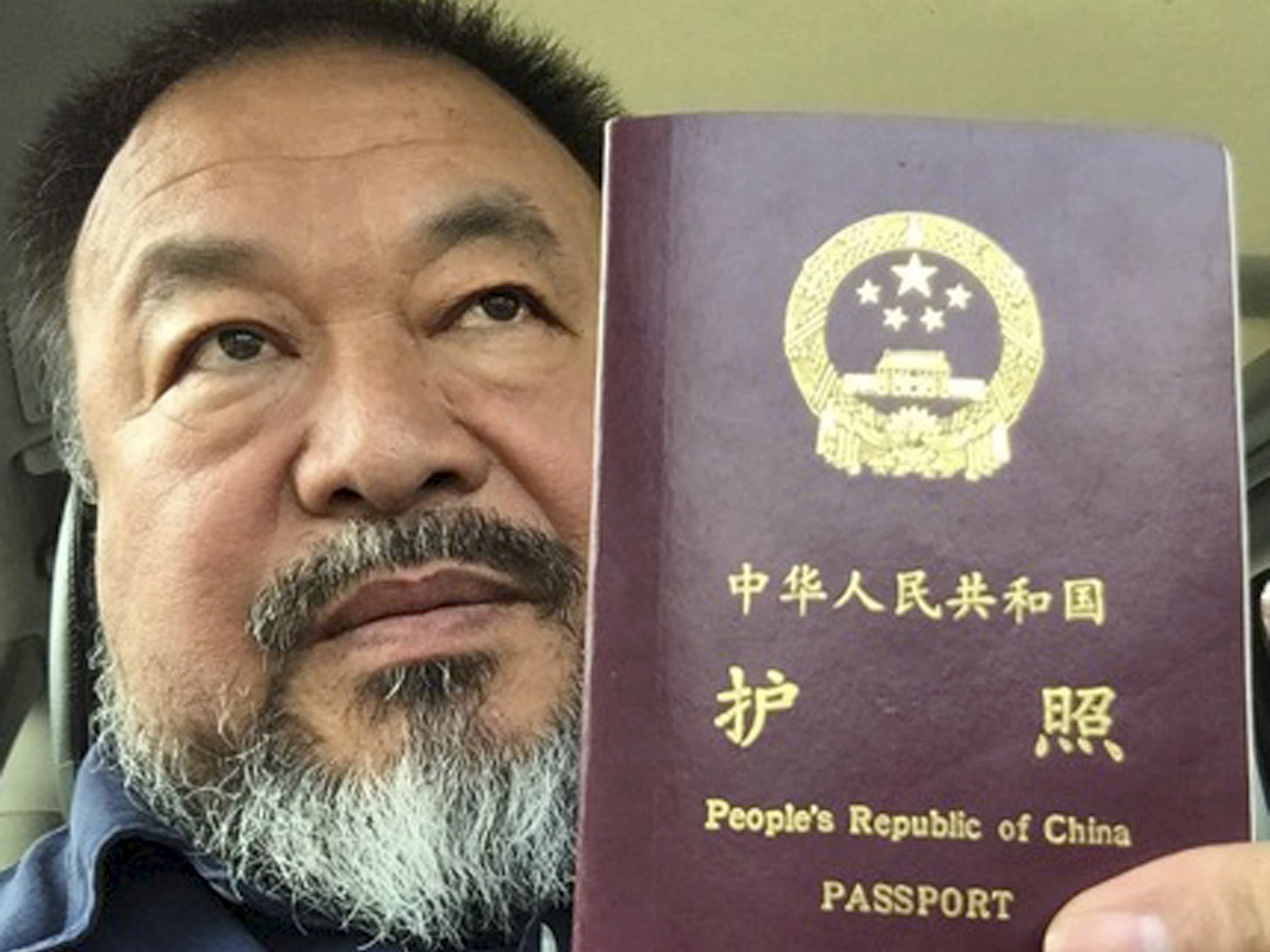 Chinese dissident artist Ai Weiwei poses with his passport in Beijing. Chinese dissident artist and free speech advocate said that authorities in Beijing returned his passport, more than four years after it was confiscated following his 81-day secret dete