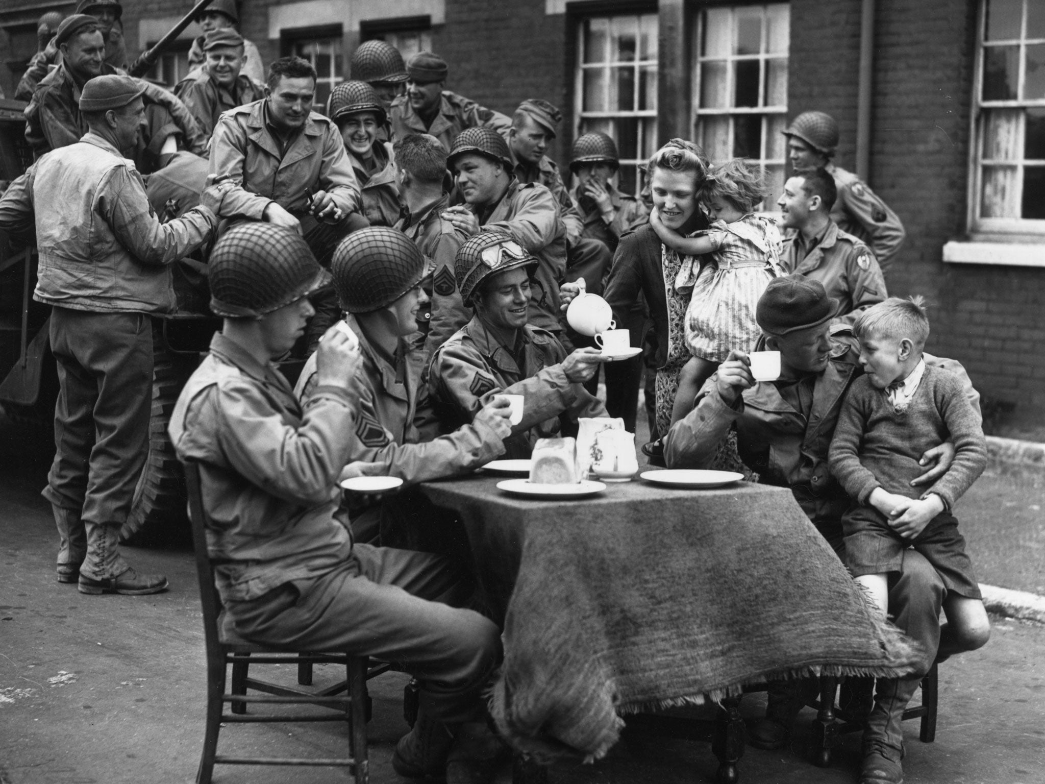 Harmless joshing?: An Englishwoman serves tea to American troops outside her house