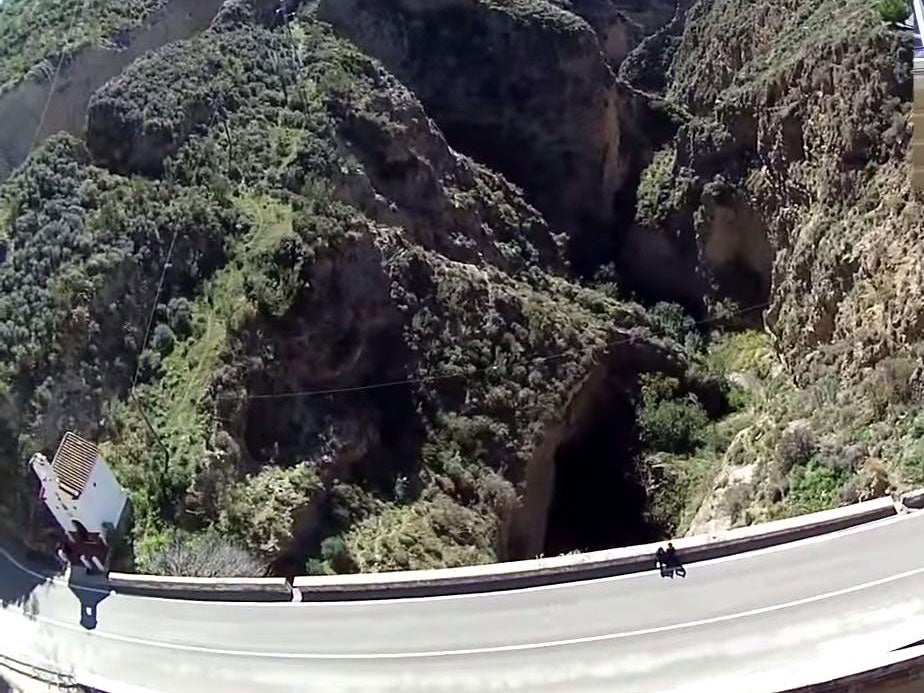 Bungee jumpers leap off the highest bridge and swing above the older two below