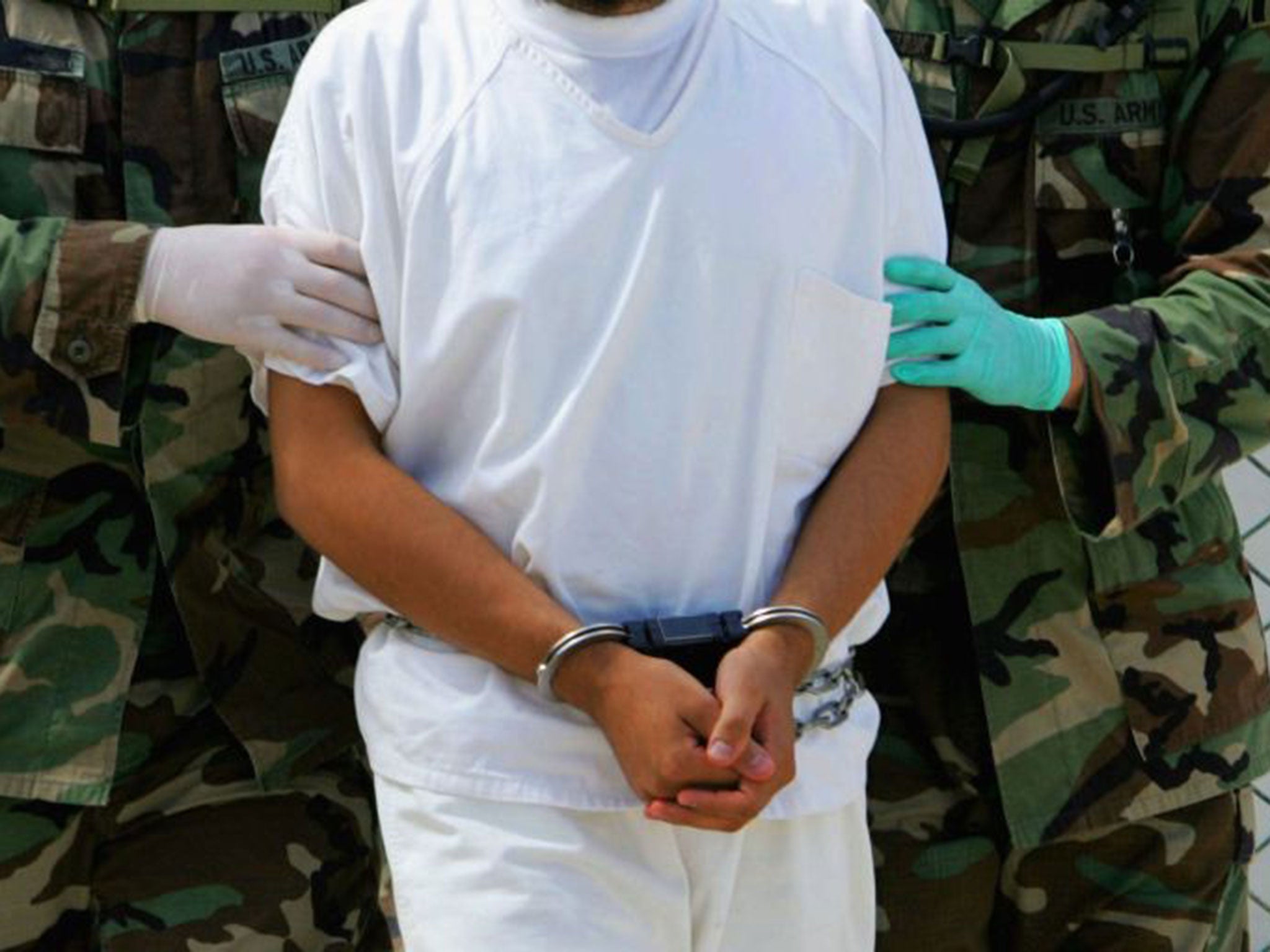 A detainee is escorted by military police at Camp 4 of the maximum security prison Camp Delta at Guantanamo Naval Base, 26 August 2004